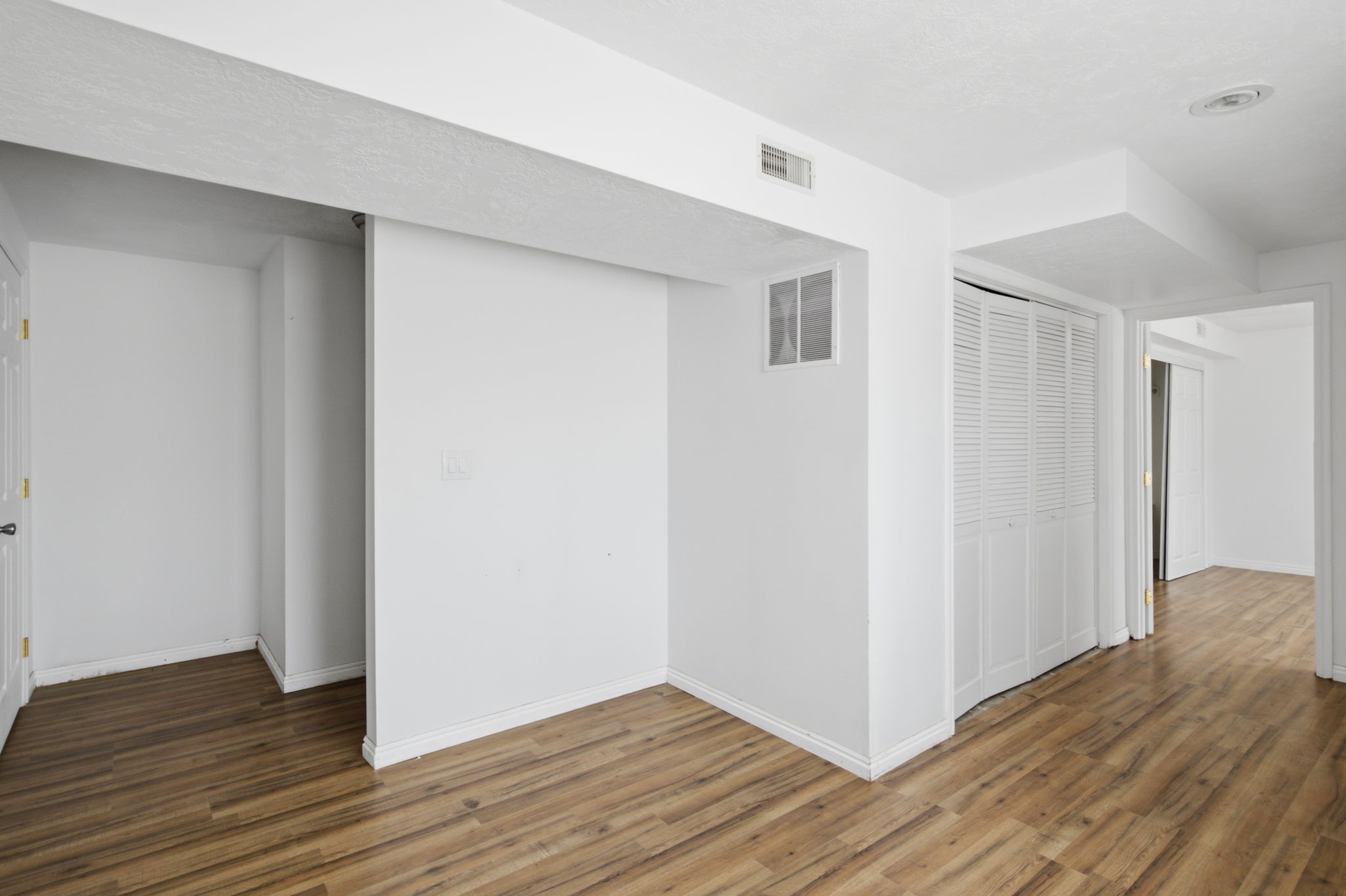 Interior space featuring wood-finish flooring, white walls, and white trim