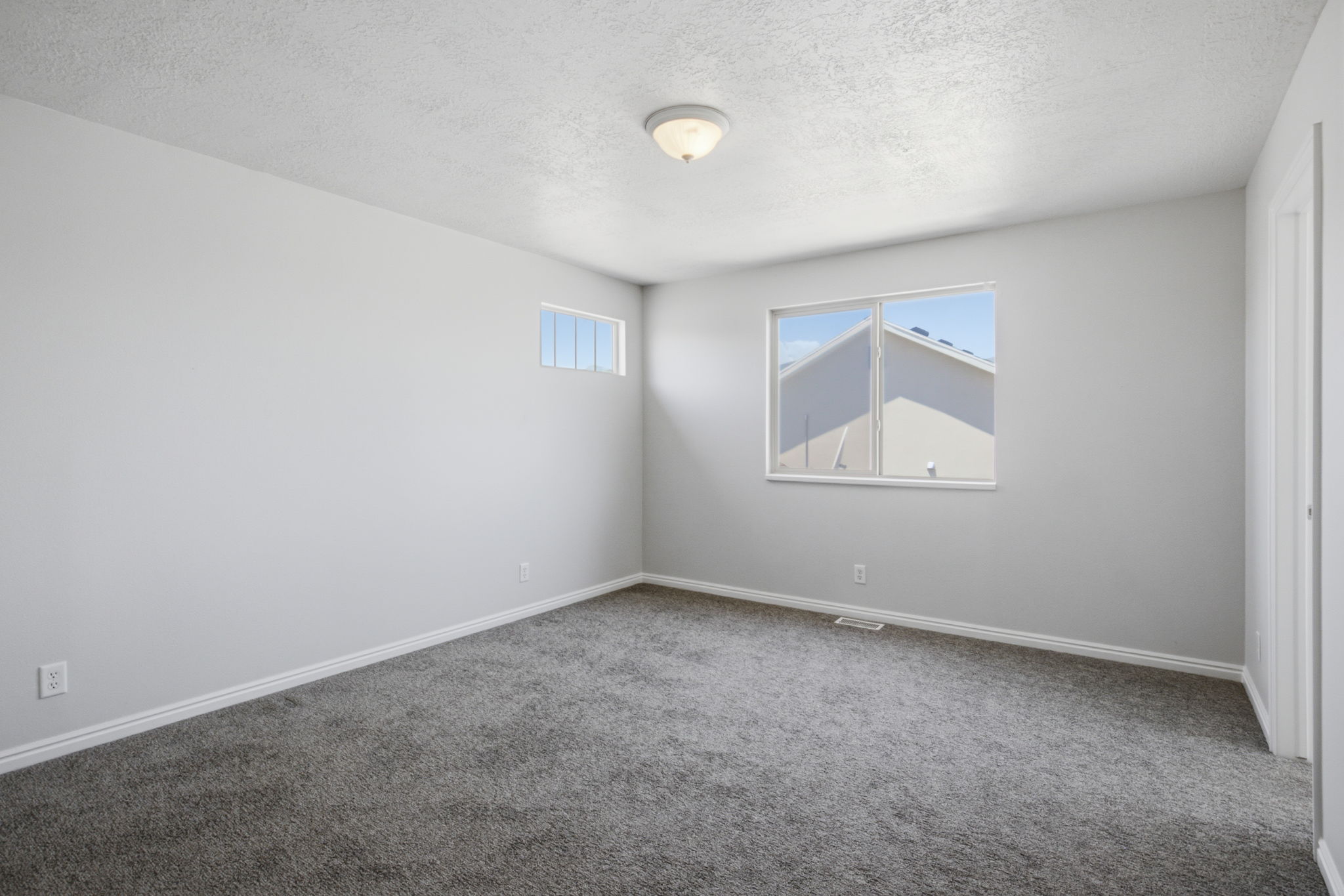 Carpeted room featuring light gray walls, white trim, and a semi-flush mount ceiling light