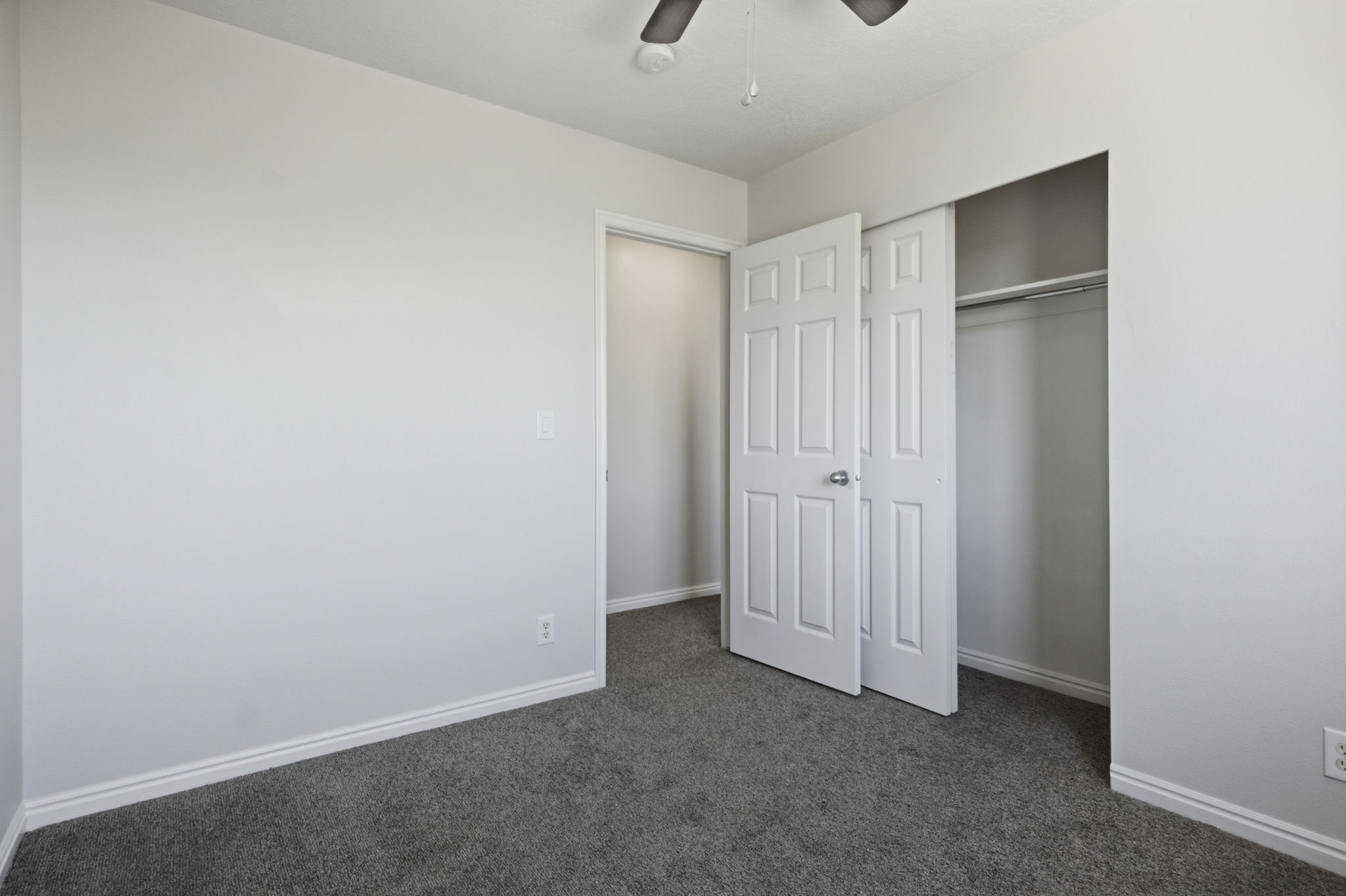Bedroom with gray carpeting and light gray walls