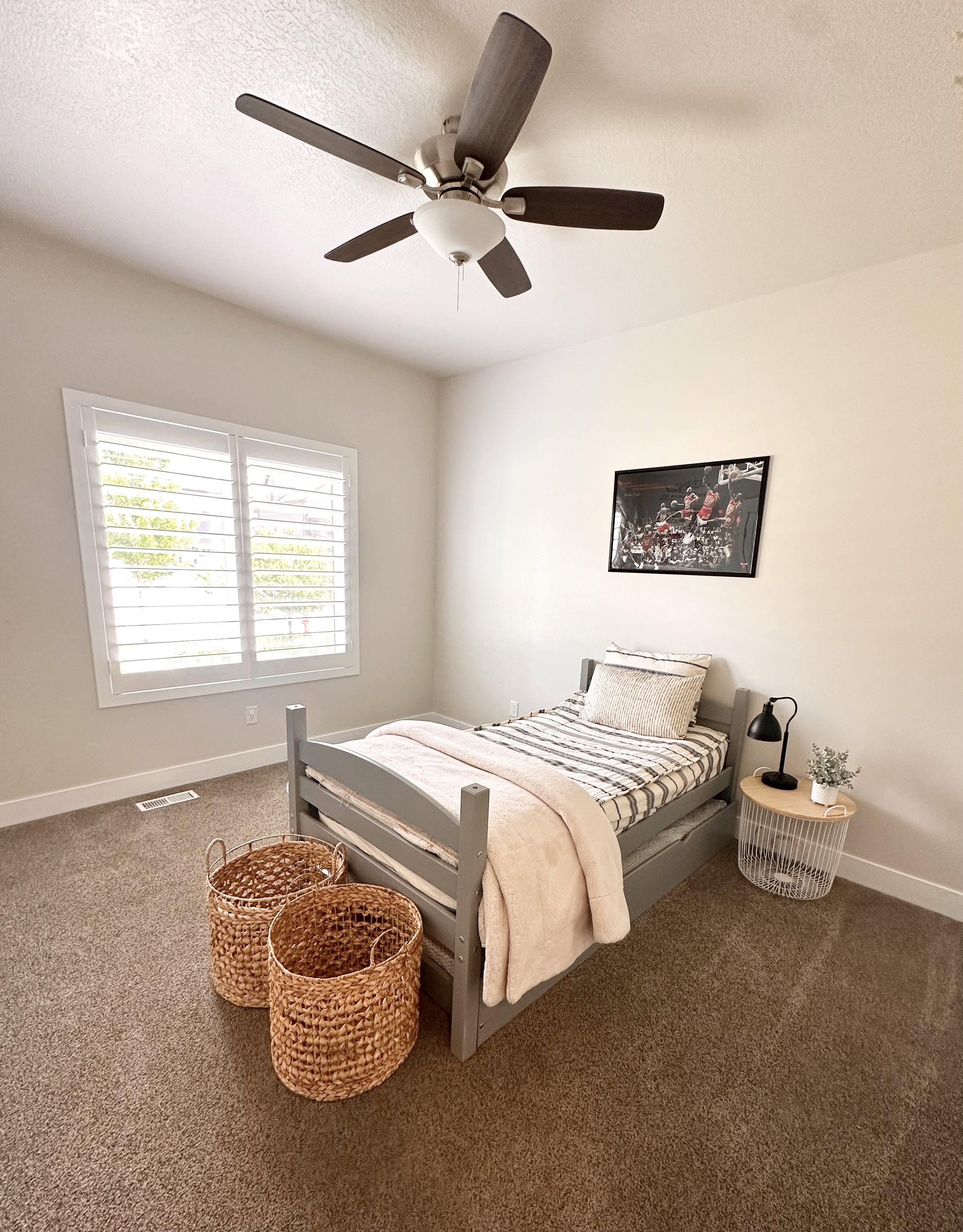 Room featuring a ceiling fan with integrated lighting, a window with white plantation shutters, and light-toned walls