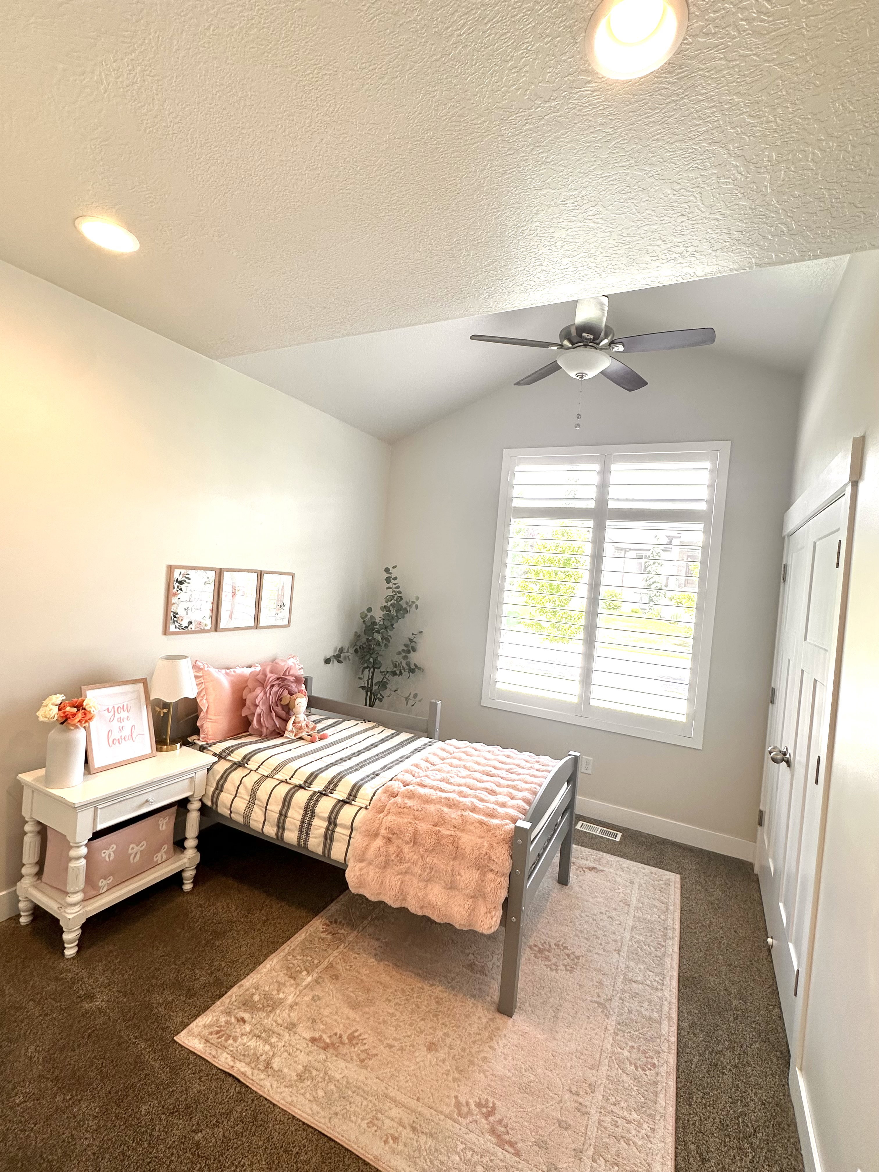 Vaulted ceiling room featuring recessed lighting, a ceiling fan, a window with plantation shutters, and a white paneled door