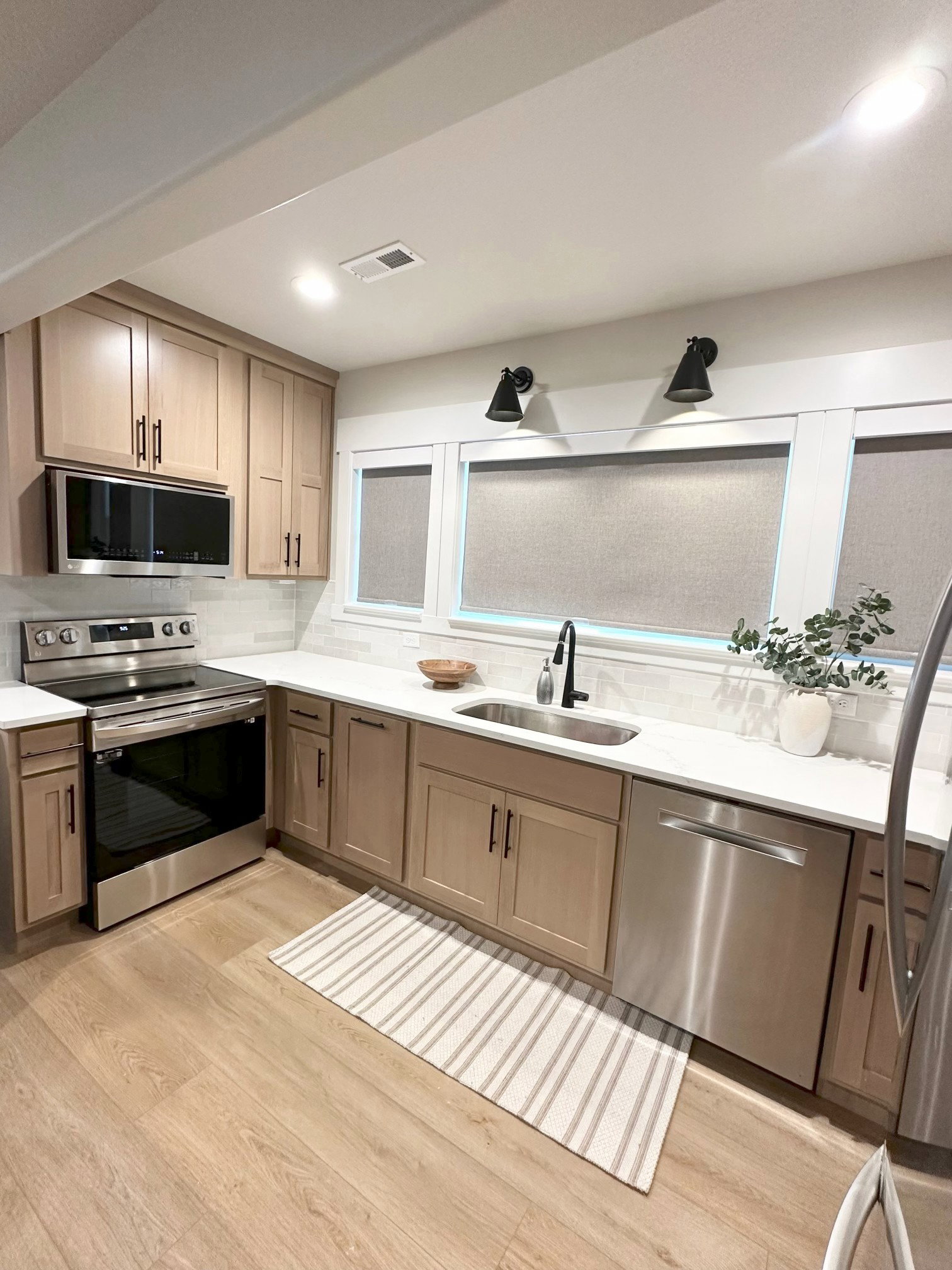 Modern kitchen featuring light wood-finish cabinetry and stainless steel appliances