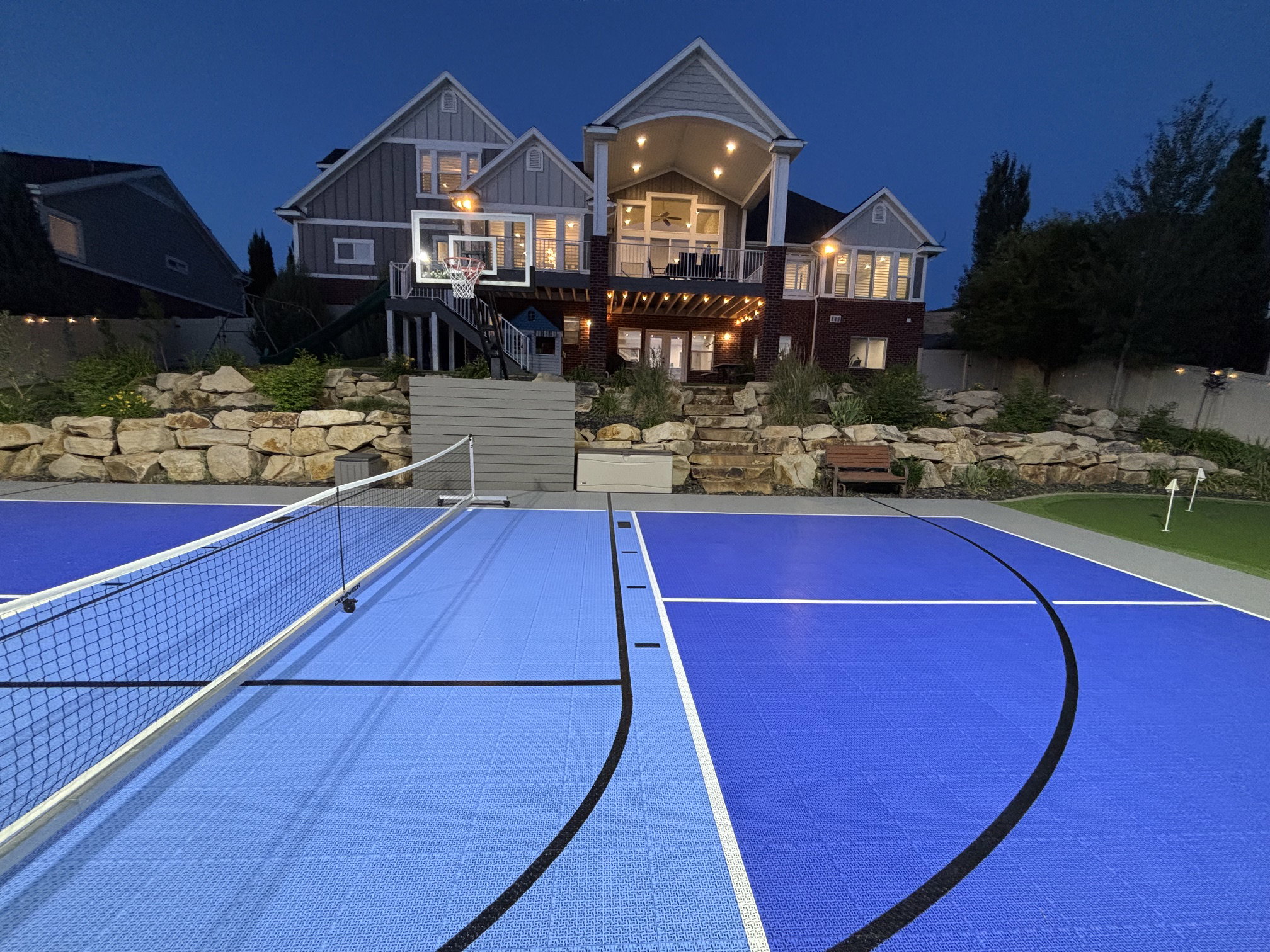 Multi-sport court featuring vibrant blue modular surfacing and a net system