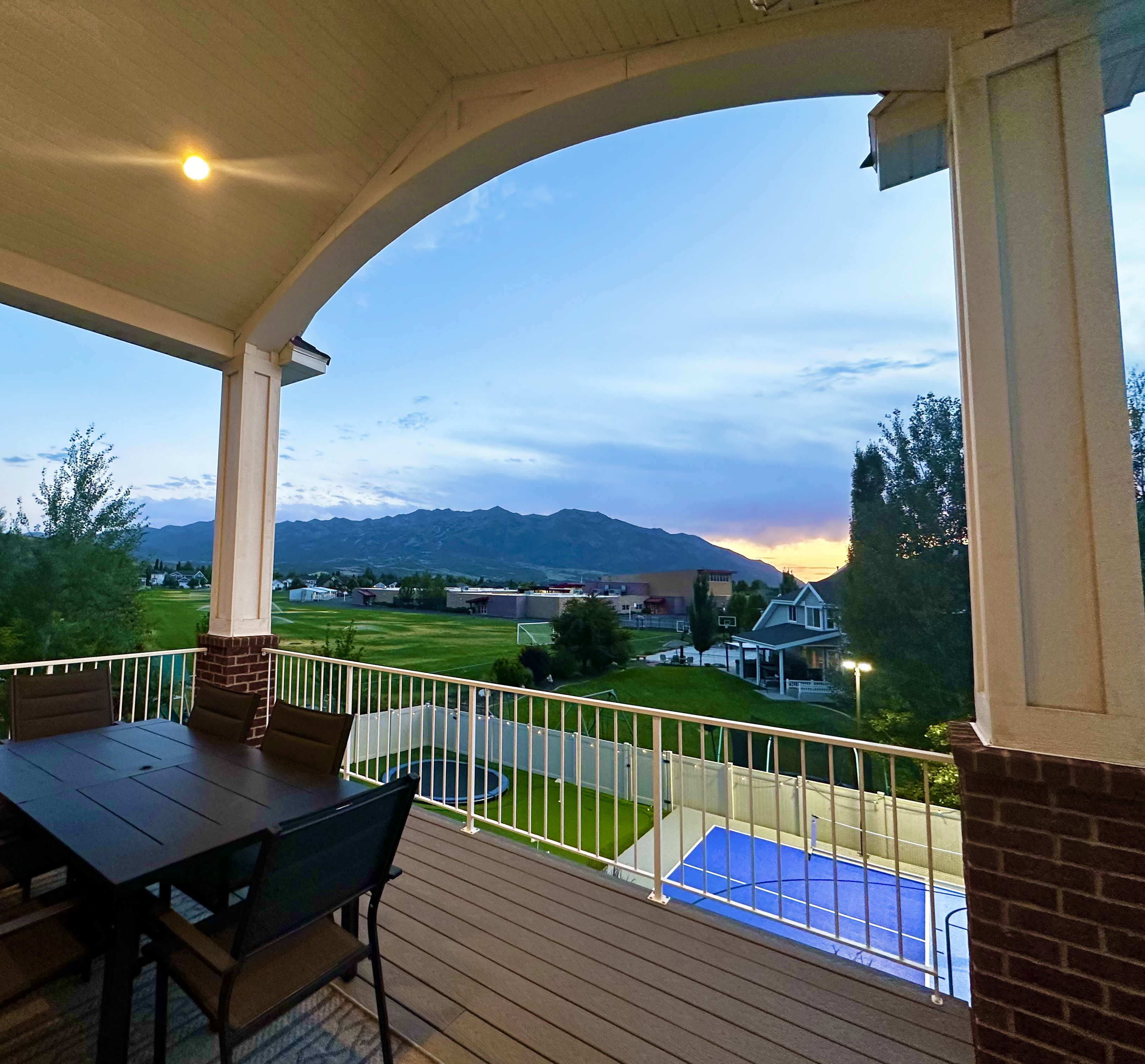 Expansive composite deck featuring a white railing and brick-clad columns