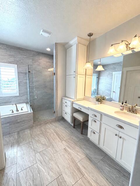 Spacious bathroom featuring large format tile flooring and a walk-in shower with a glass enclosure