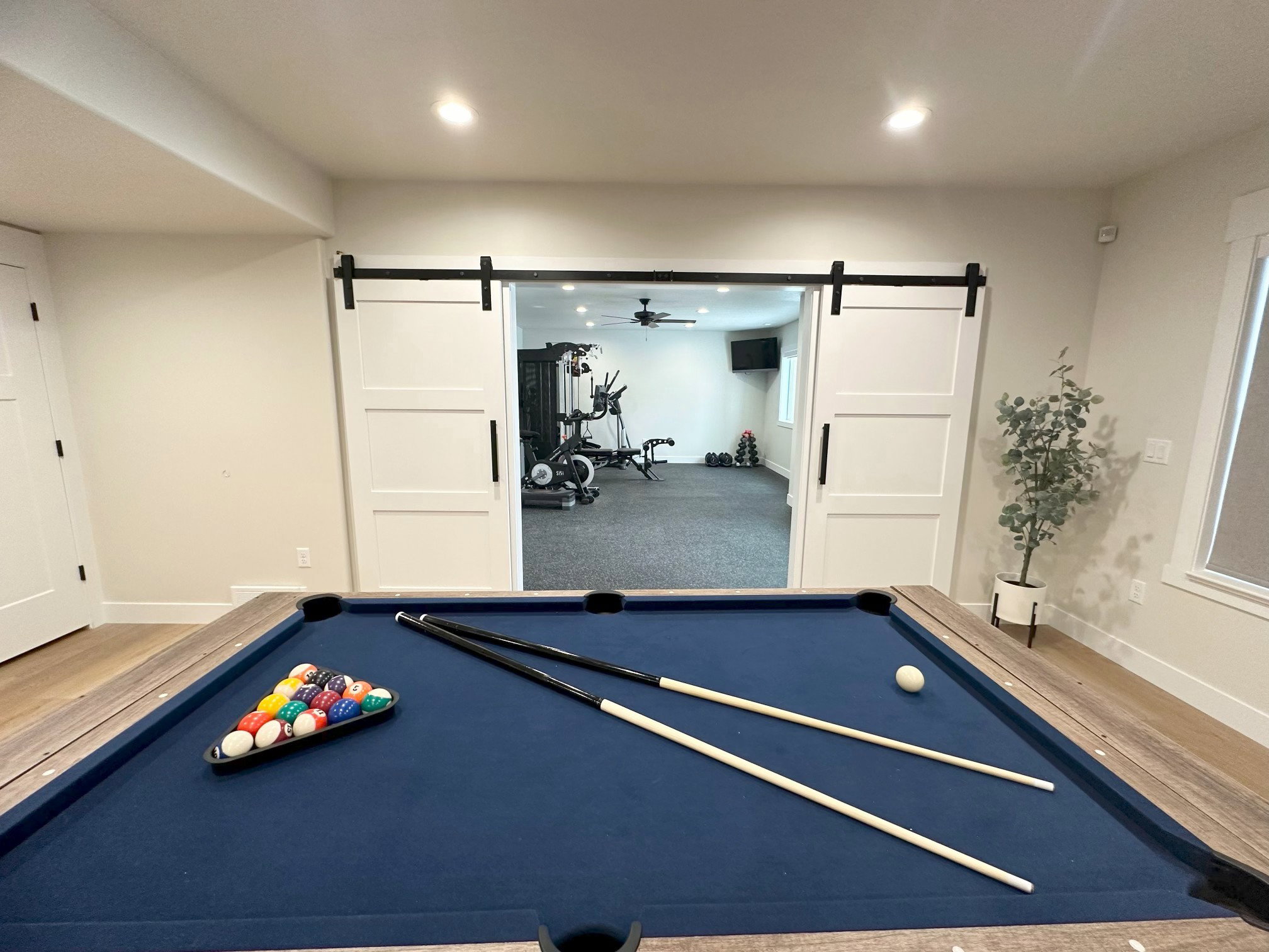 Recreation room featuring a pool table with wood-finish trim and barn door entry to an additional space