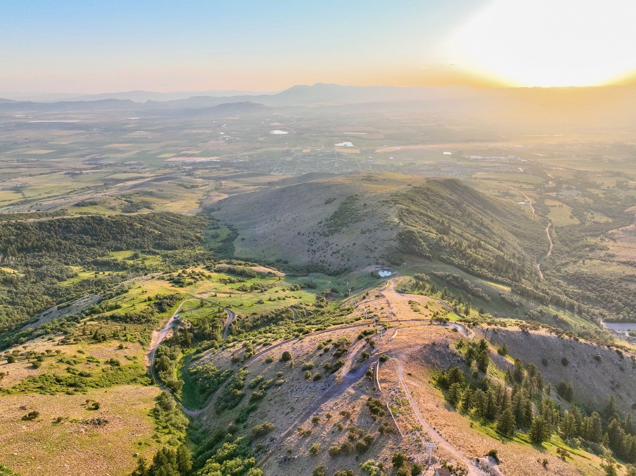 Expansive mountain and valley landscape featuring rolling hills and distant plains
