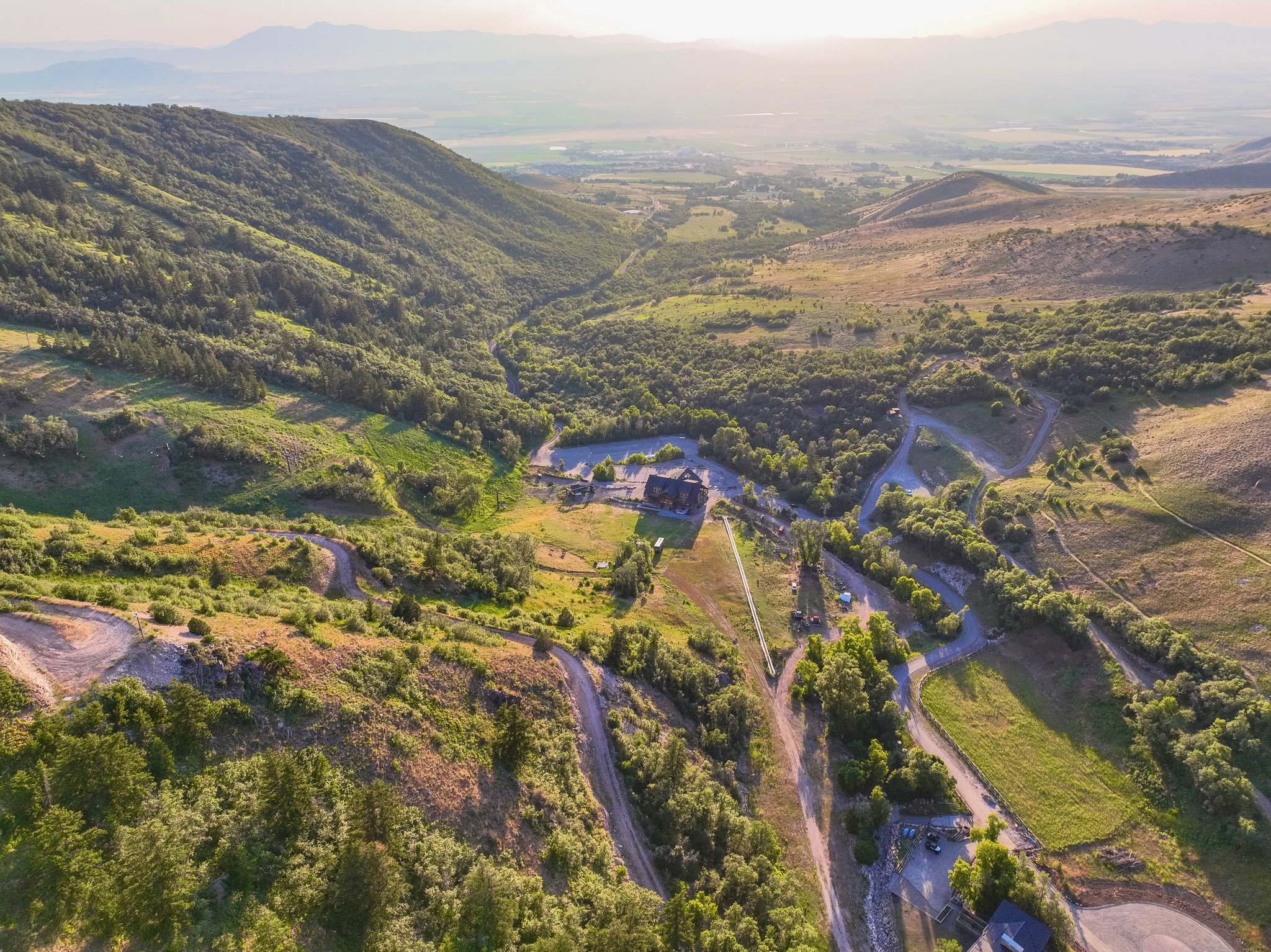 Expansive mountain property featuring a large lodge-style building, multiple winding paths, and abundant natural foliage
