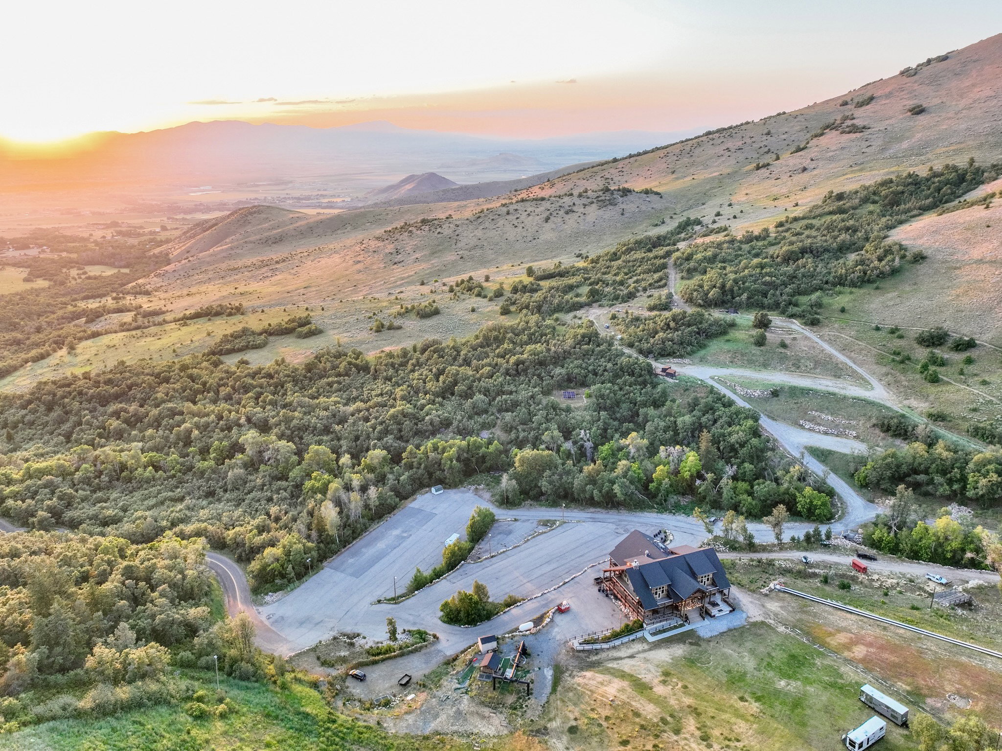 Expansive mountain property featuring a large lodge-style building with a dark roof and extensive parking areas