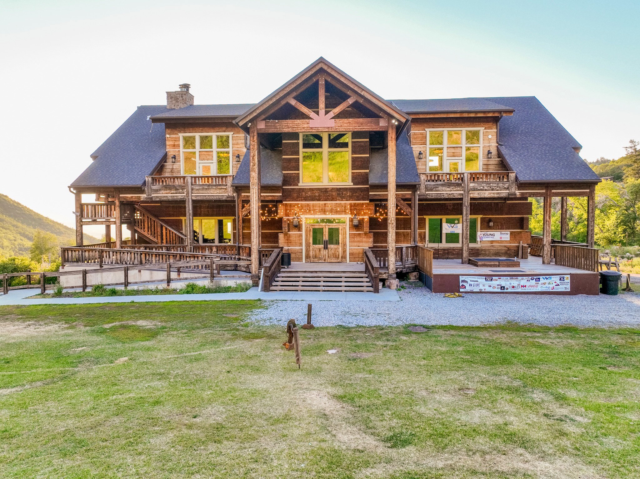 Expansive log-style exterior featuring multiple levels of balconies, a prominent gable roofline, and a multi-tiered entry with a covered porch