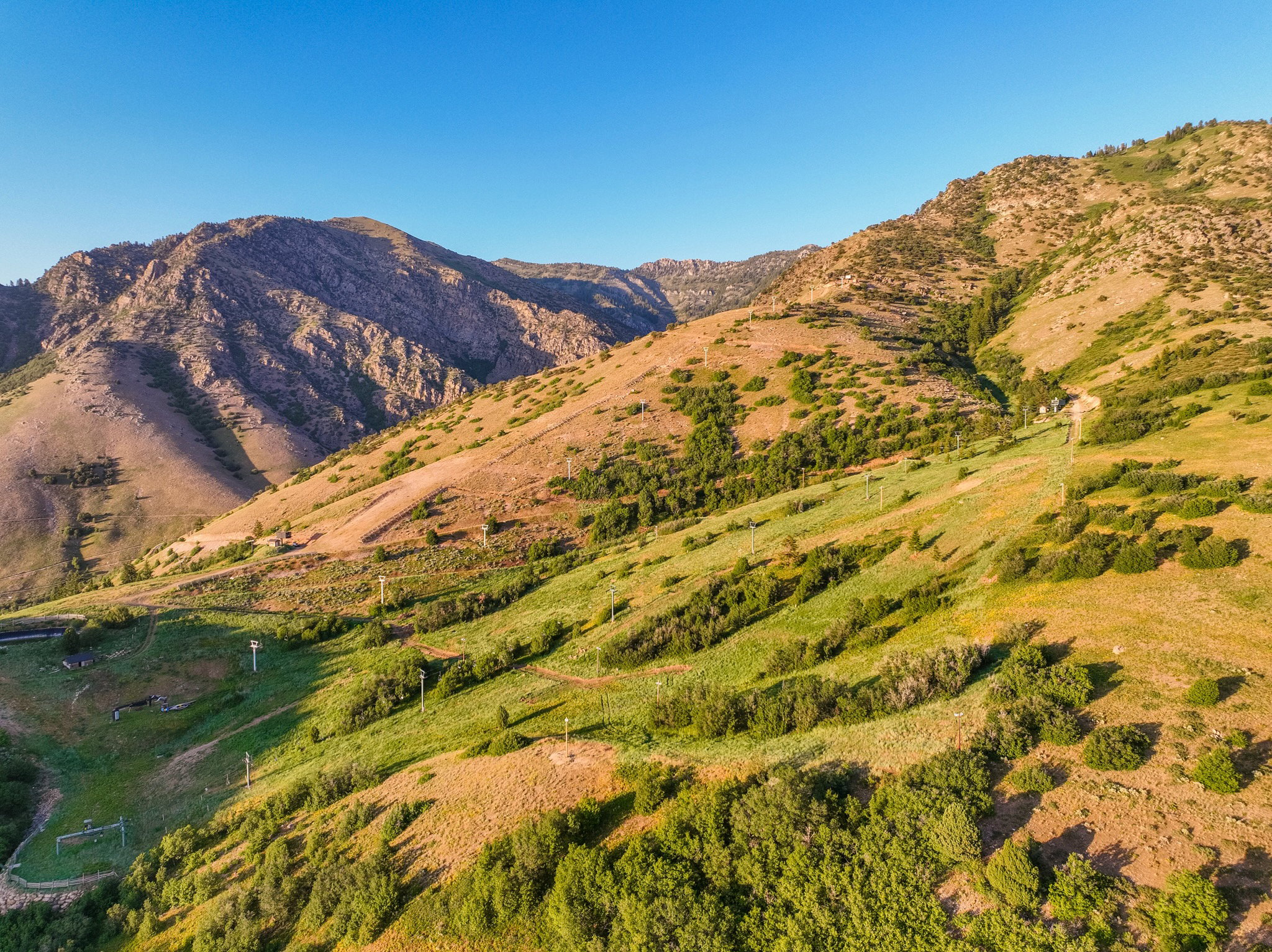 Mountainous terrain with varying elevations, featuring natural vegetation and a clear sky
