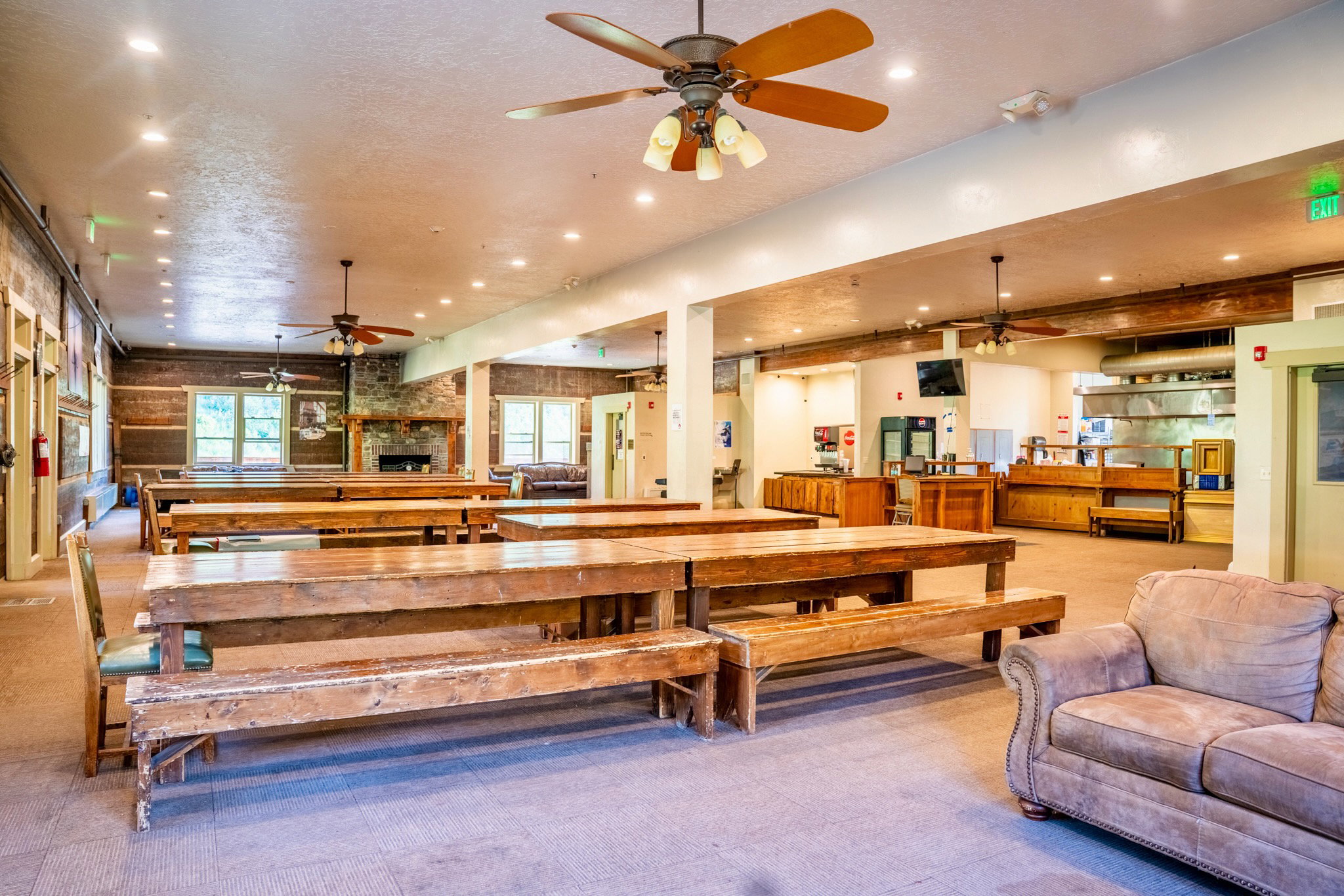 Spacious common area featuring recessed lighting, multiple ceiling fans, and exposed wood beams