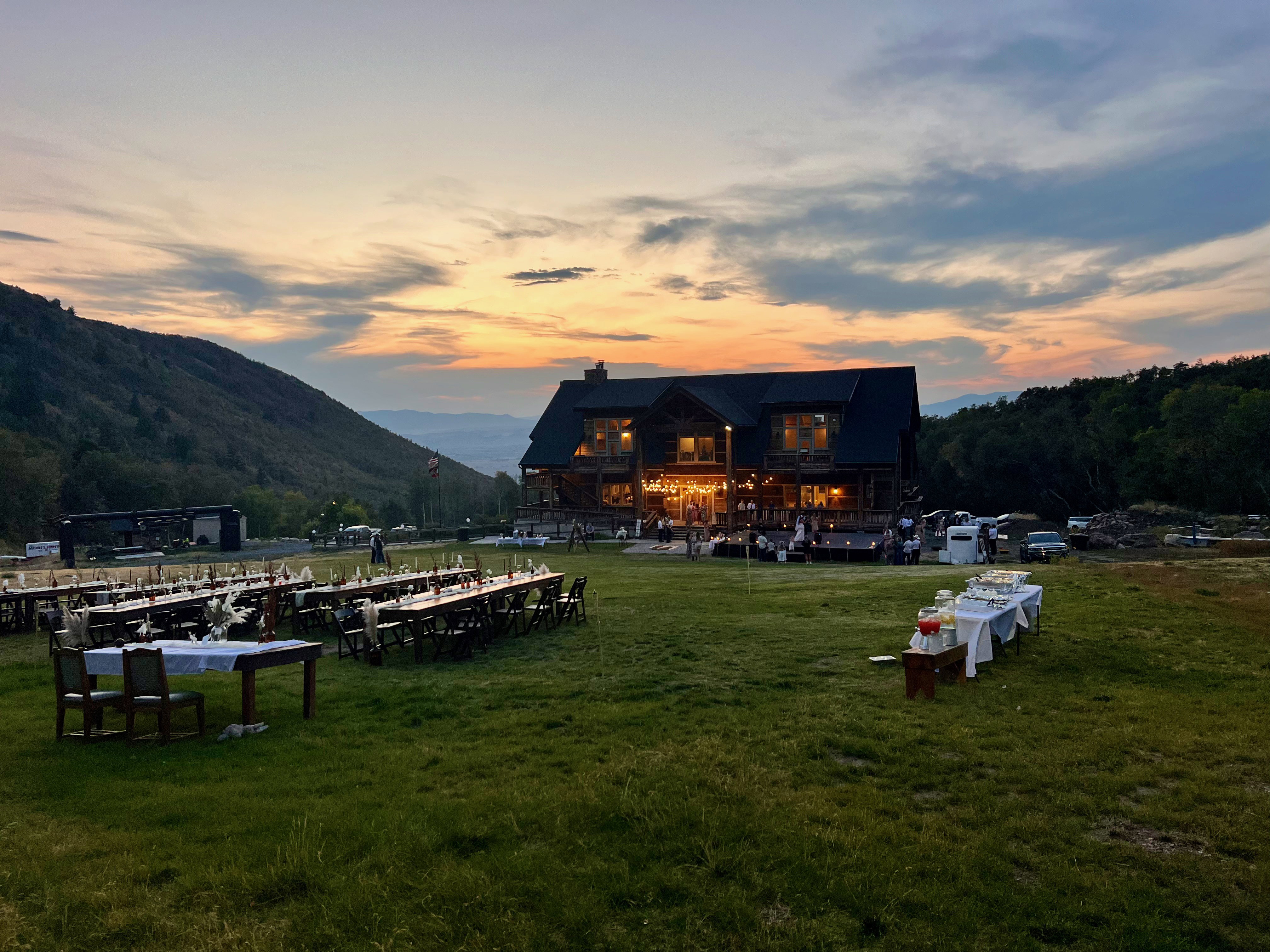 Expansive mountain property featuring a large lodge-style building with multiple stories and a prominent deck