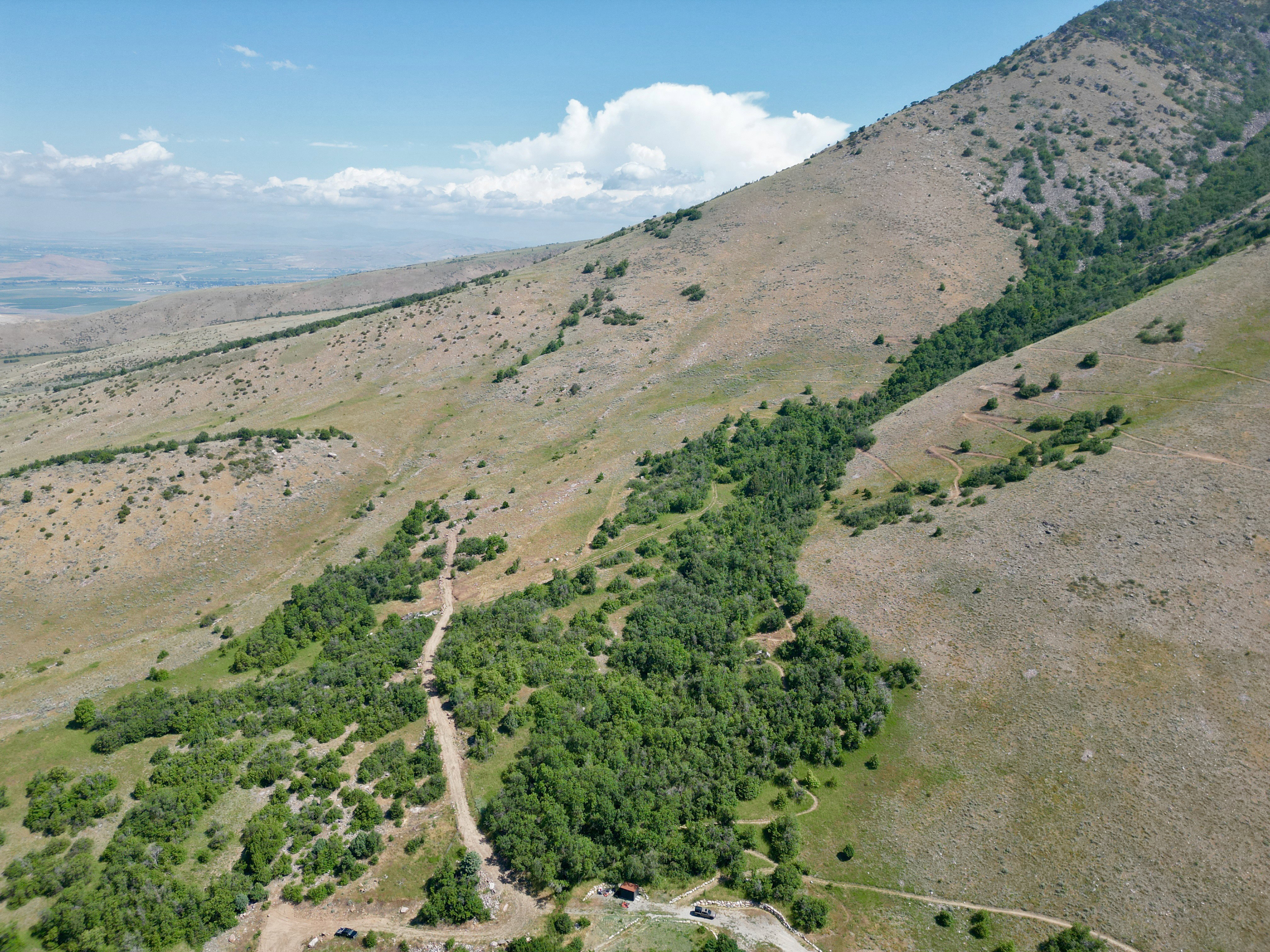 Expansive mountain terrain featuring natural vegetation and distant landscape