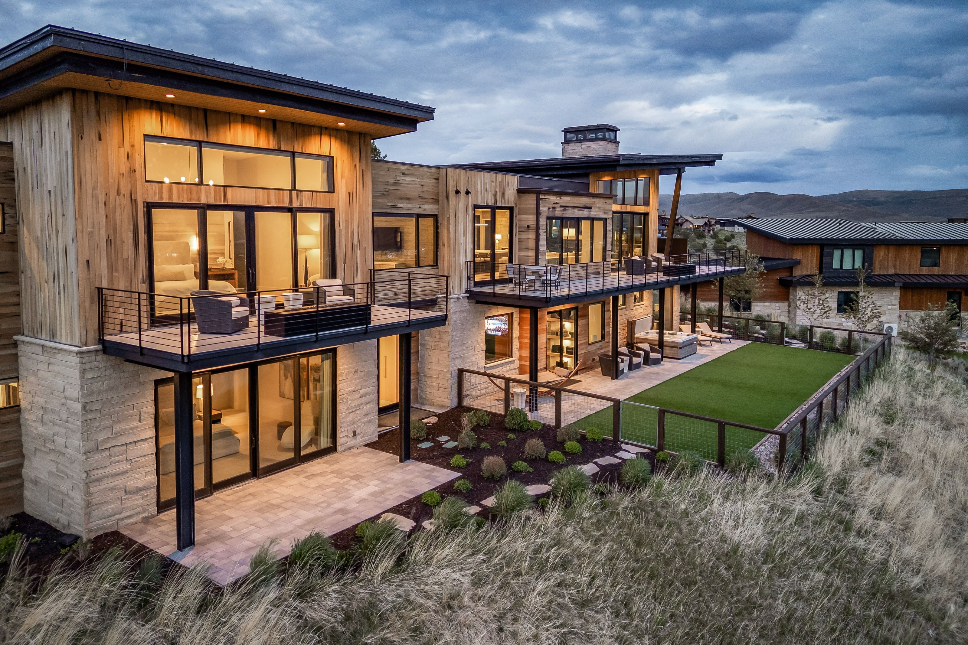 Contemporary multi-level residence featuring wood-finish siding and stone accents