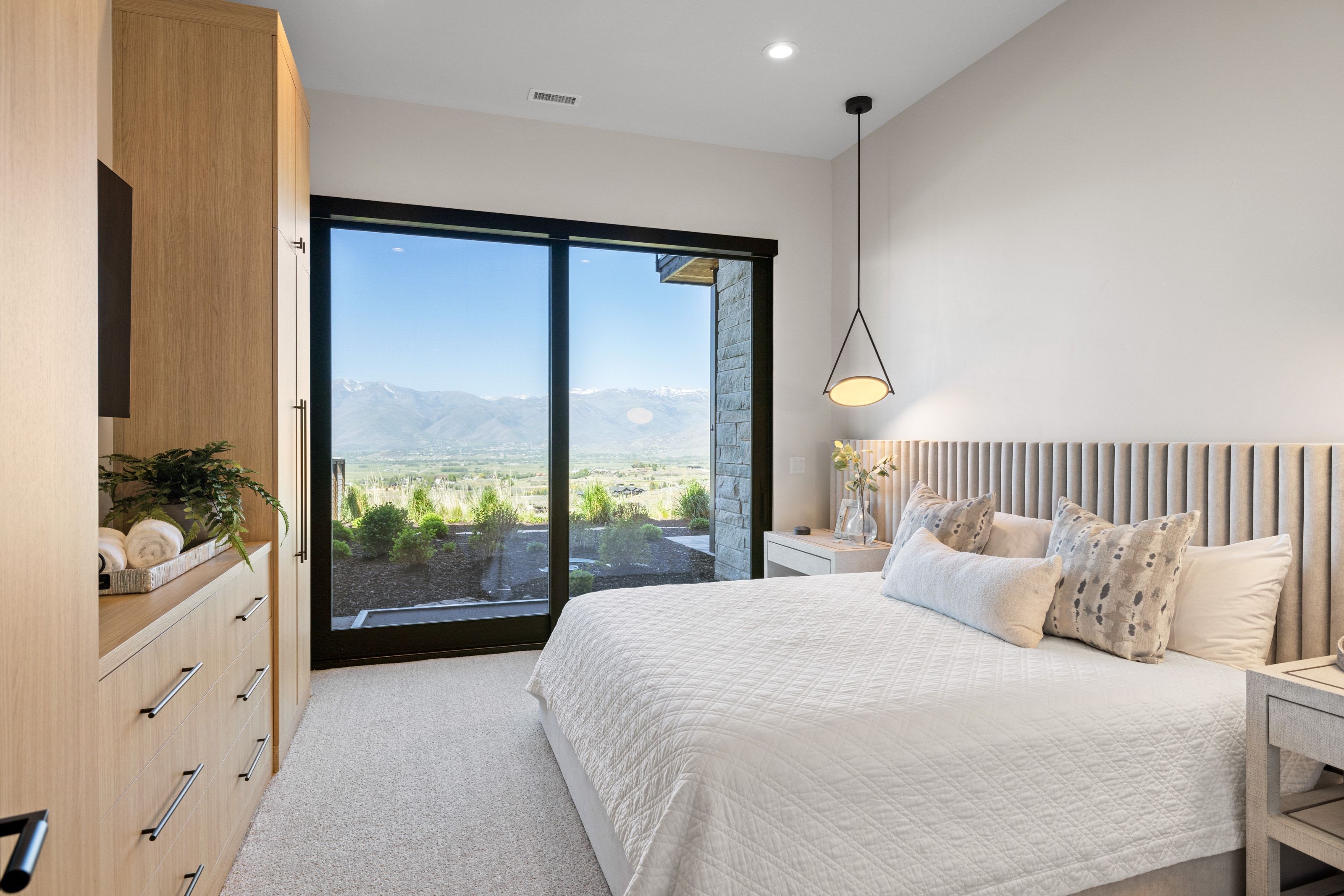Bedroom featuring a full-height glass door, large picture window, custom built-in cabinetry, and recessed lighting