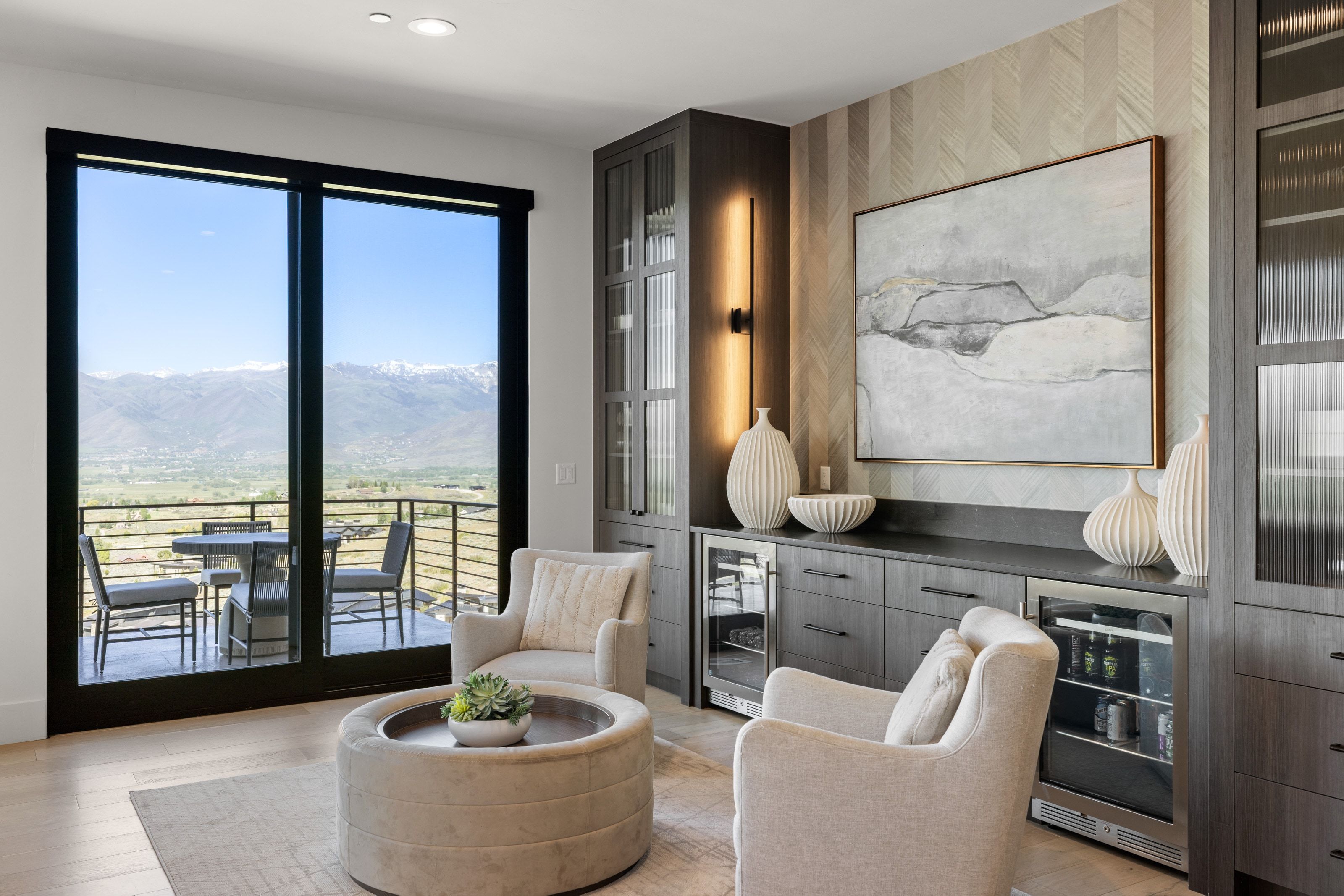 Expansive glass sliding doors open to a balcony with mountain scenery