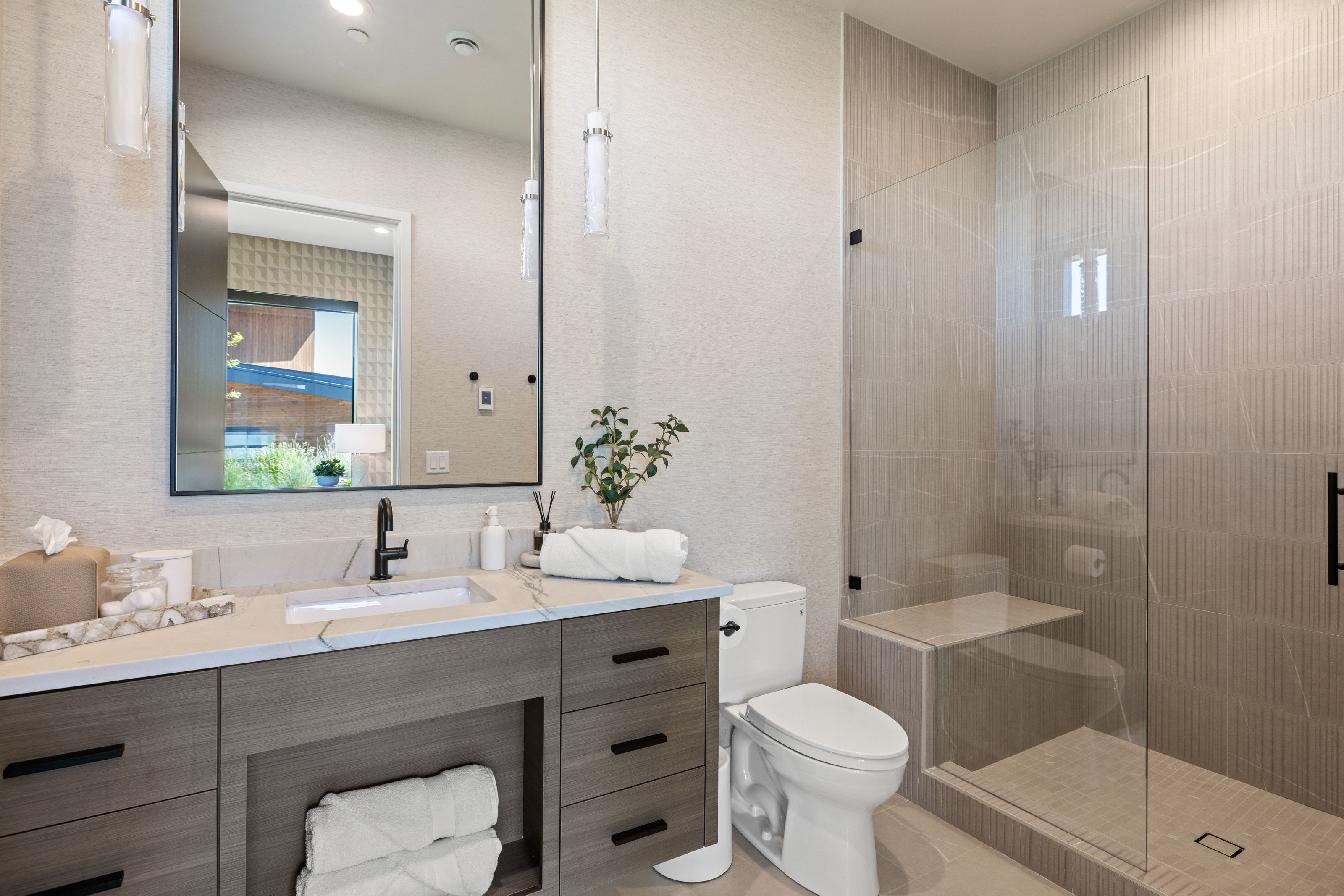 Bathroom featuring a wood-finish vanity with a built-in sink and stone-look countertop