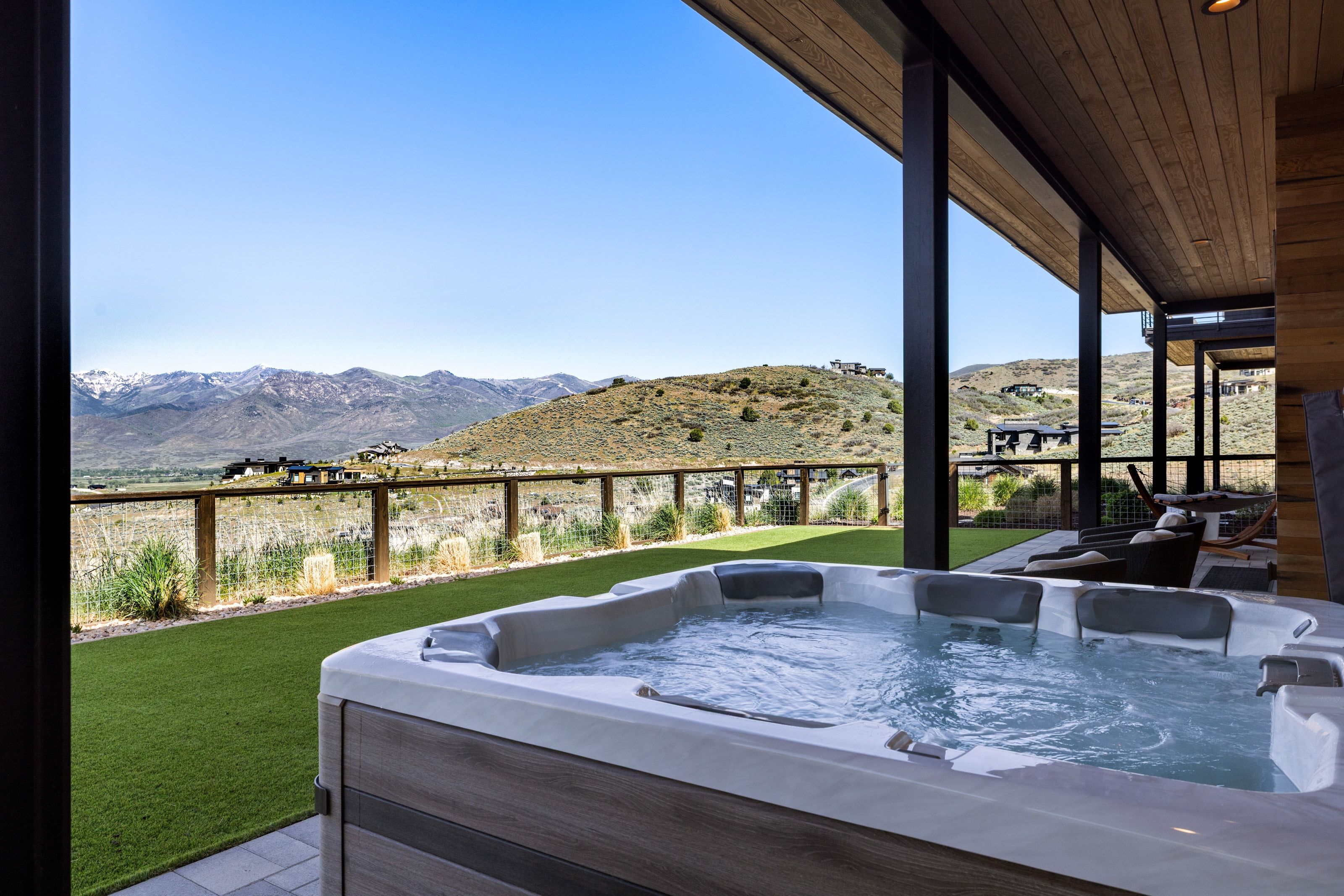 Outdoor hot tub on a tiled patio, featuring a wood-finish exterior and integrated headrests