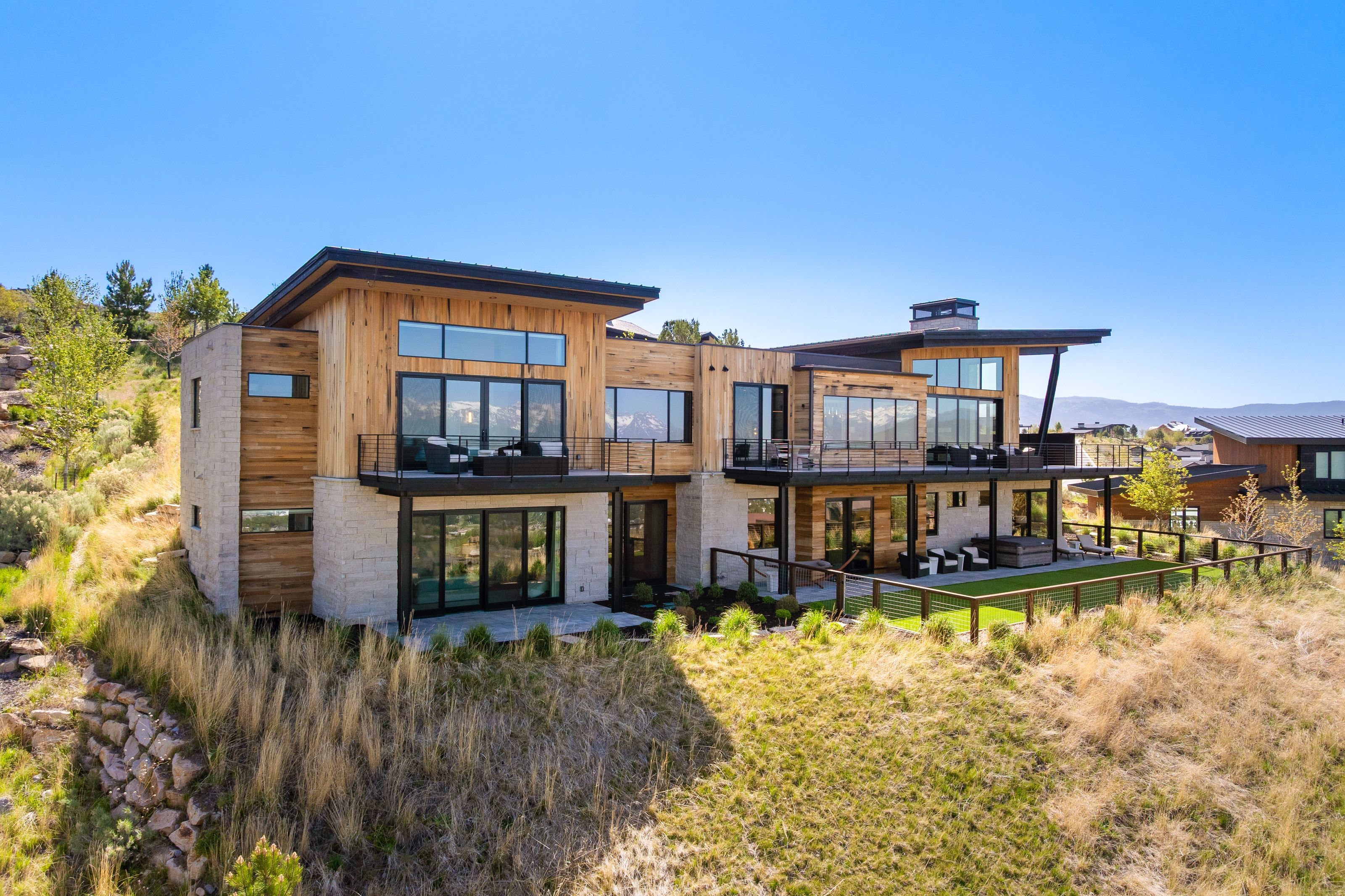 Contemporary multi-level residence featuring natural wood siding and stone accents