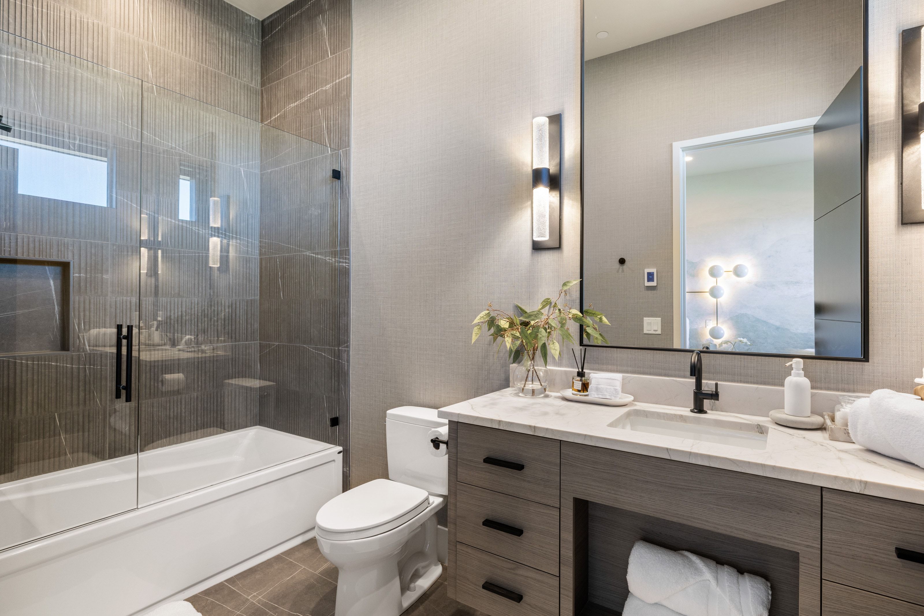 Contemporary bathroom featuring a floating wood-finish vanity with a white countertop and integrated sink