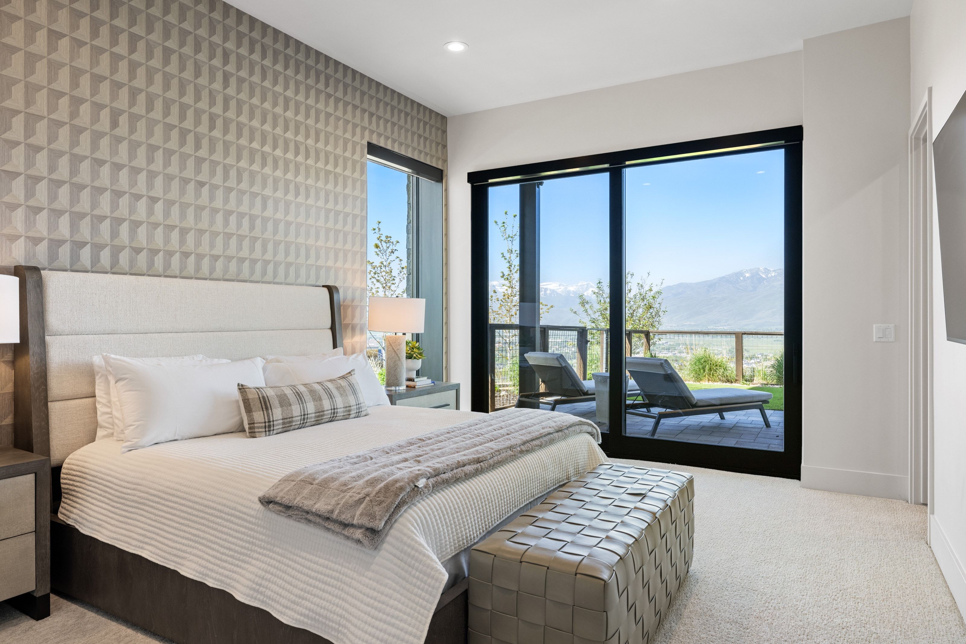 Sliding glass doors opening to a private patio, textured accent wall, recessed lighting, and carpeted flooring