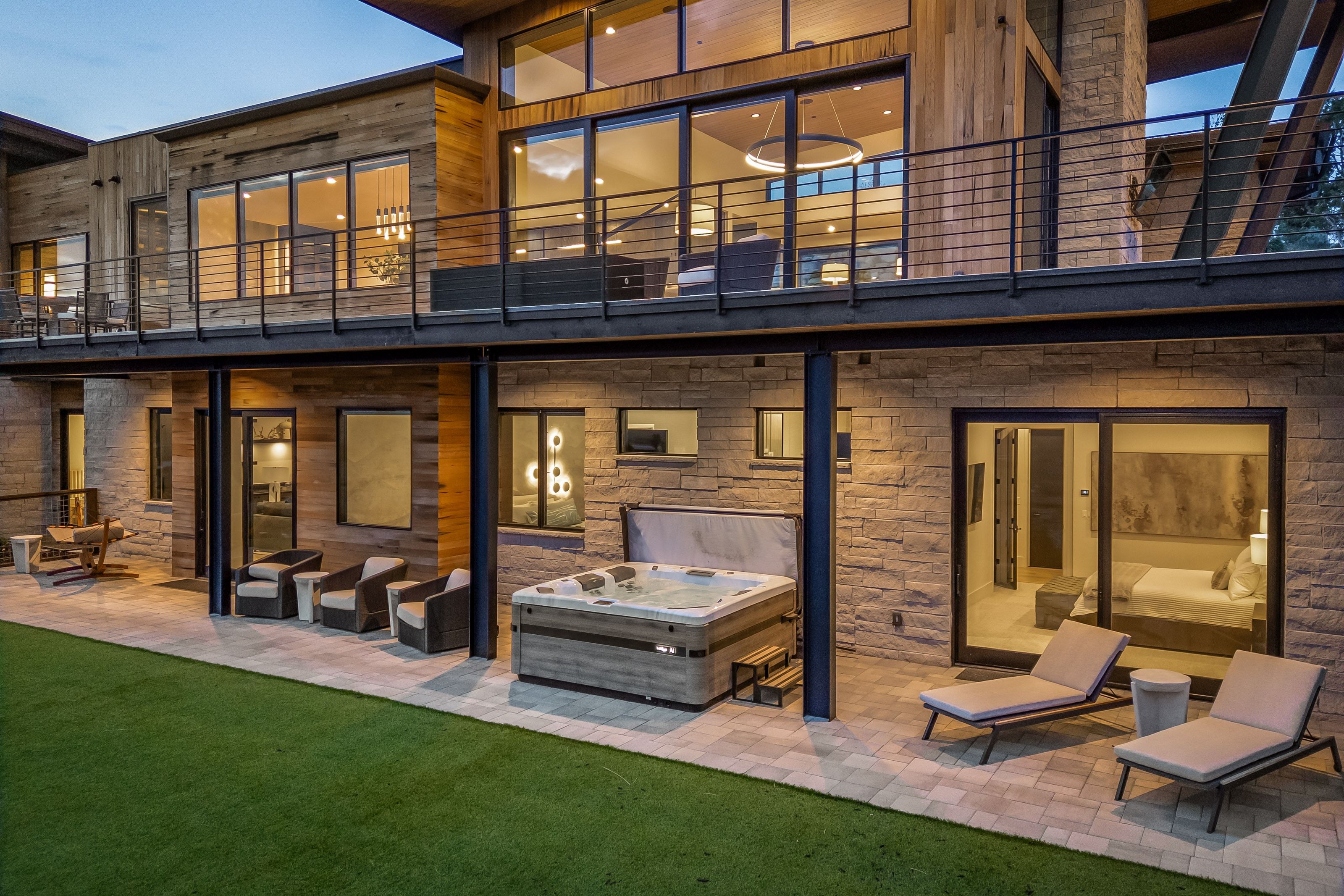 Modern multi-level exterior featuring stacked stone and wood-finish siding