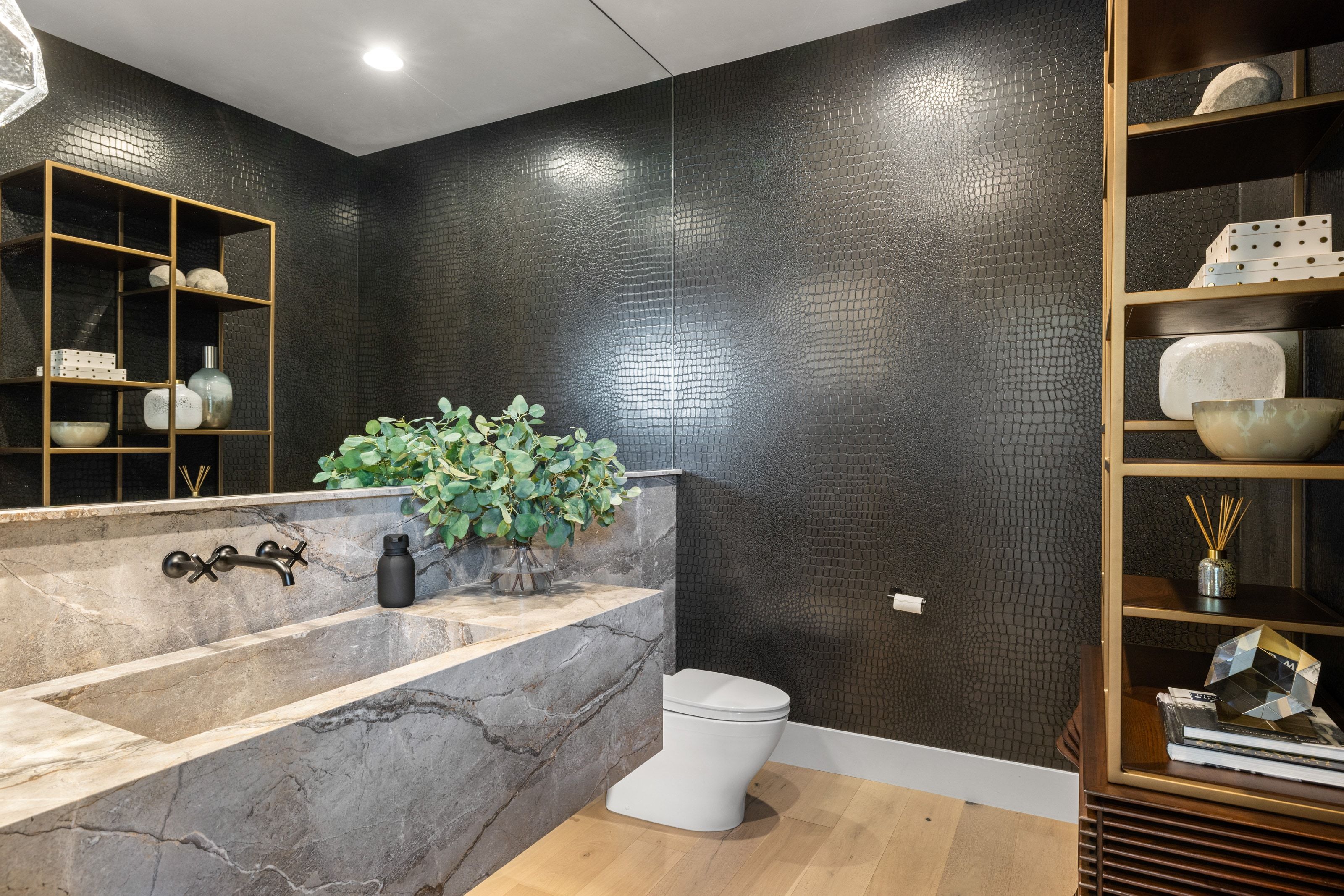 Floating stone vanity with integrated sink and wall-mounted faucet