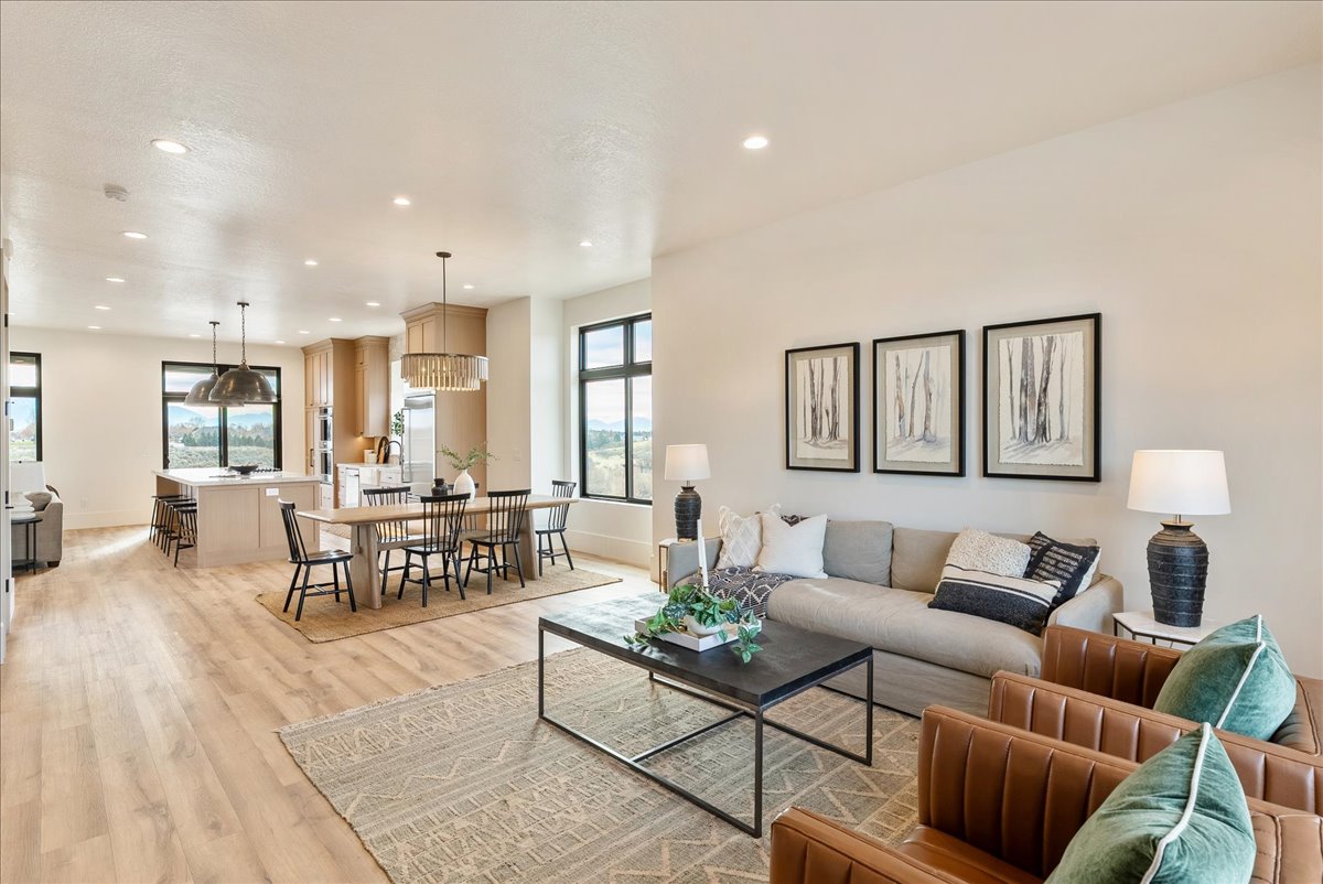 Open-concept living space featuring wood-finish flooring, recessed lighting, and large windows