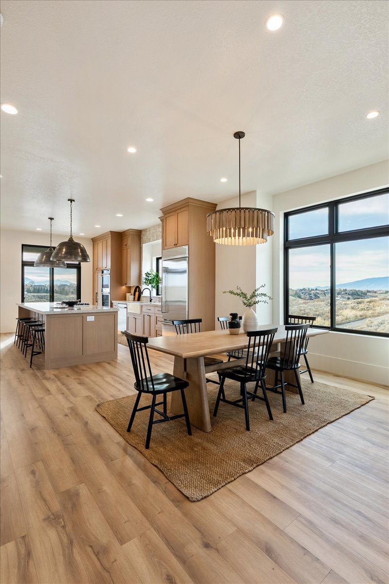 Open-concept living space featuring wood-finish flooring, recessed lighting, and a modern kitchen with a large island