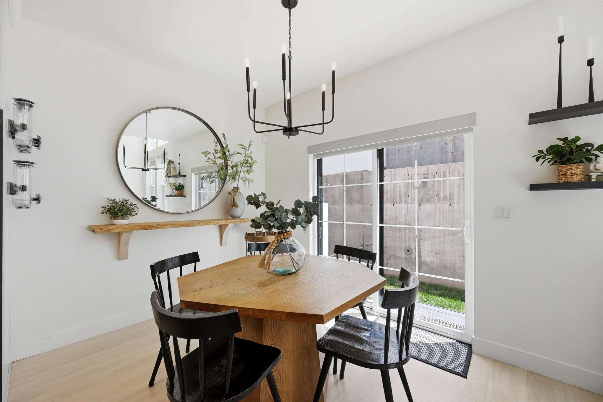 Dining area featuring a modern black chandelier, and a sliding glass door