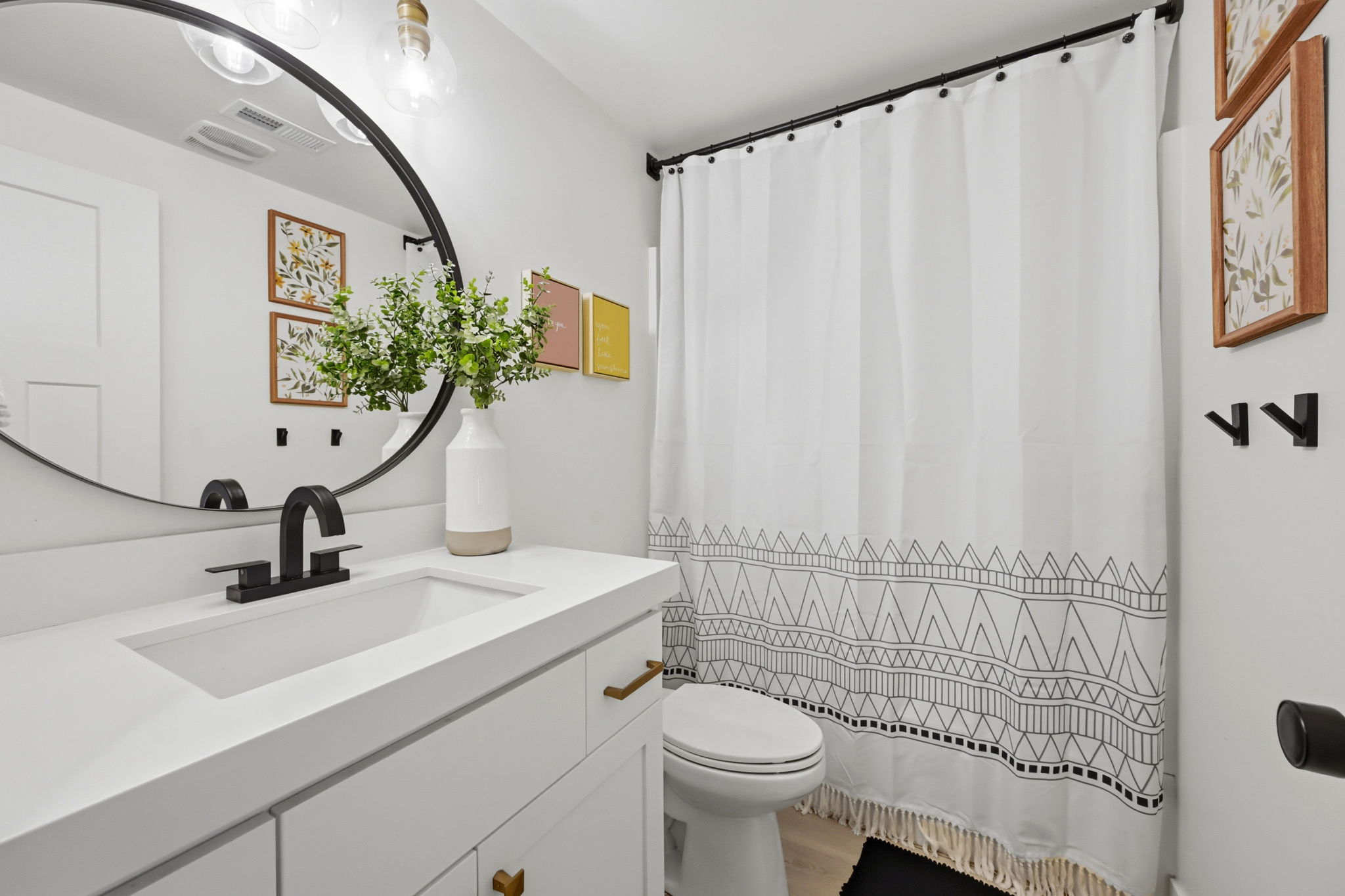 Modern bathroom featuring a white vanity with brass-tone hardware and an integrated sink