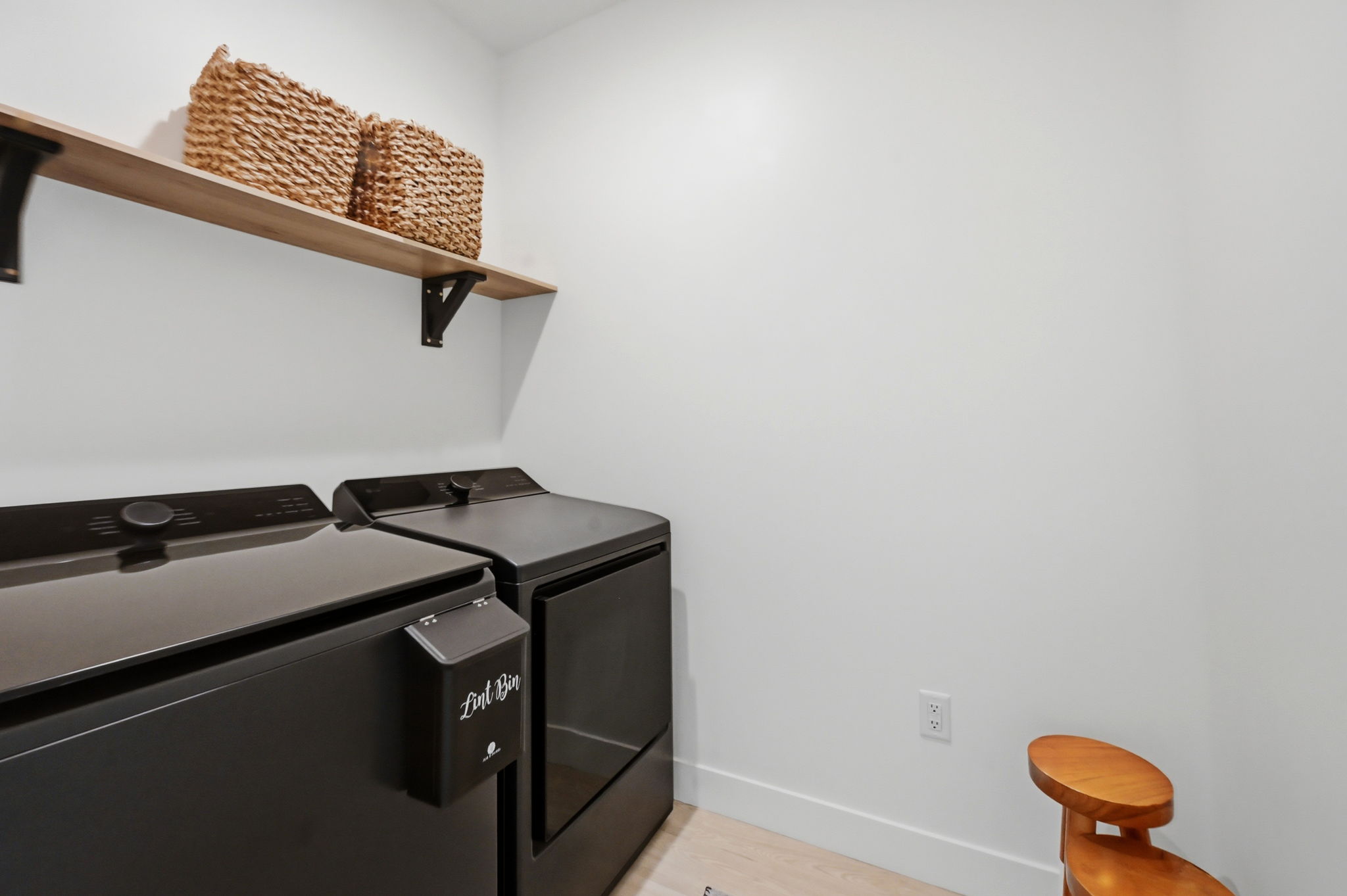 Dedicated laundry area featuring a wood-finish floating shelf