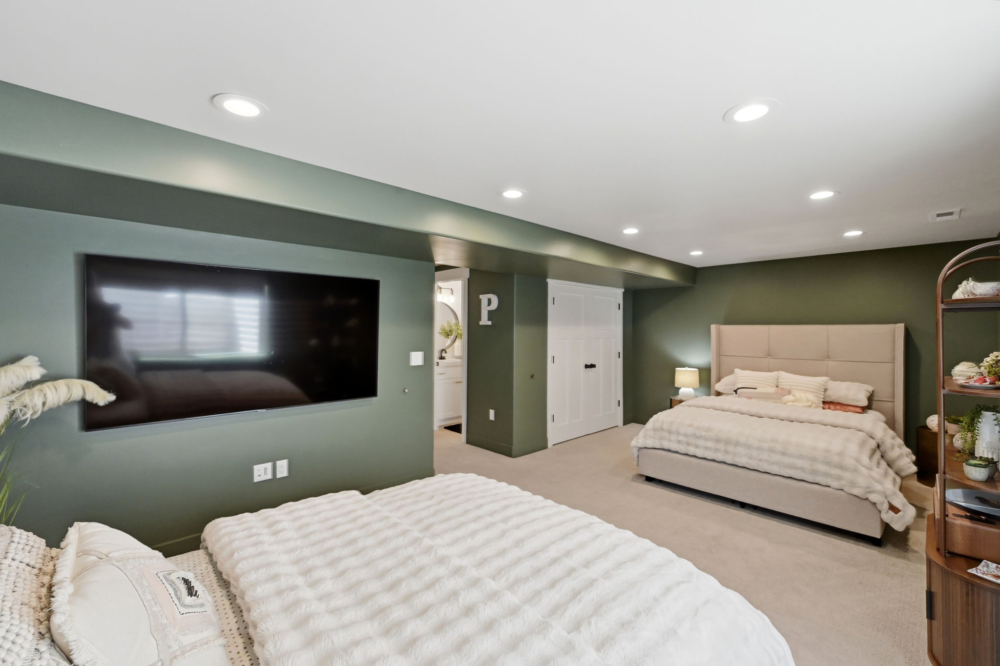 Spacious room featuring recessed lighting, a neutral carpeted floor, and two sets of white bifold closet doors