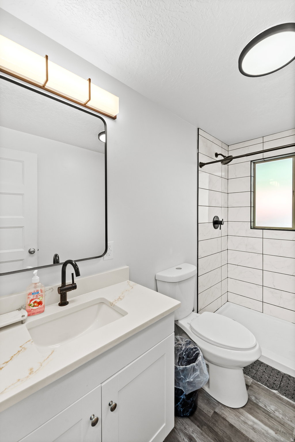 Bathroom featuring a white vanity with a light-colored countertop, an undermount sink, and a black faucet