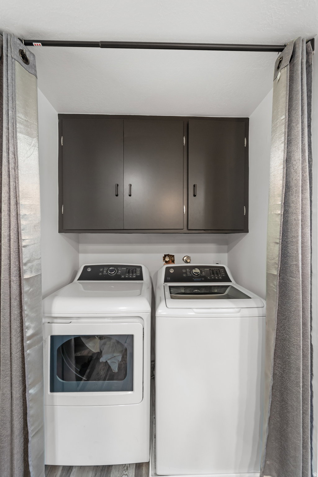 Dedicated laundry area featuring a white GE dryer and washer