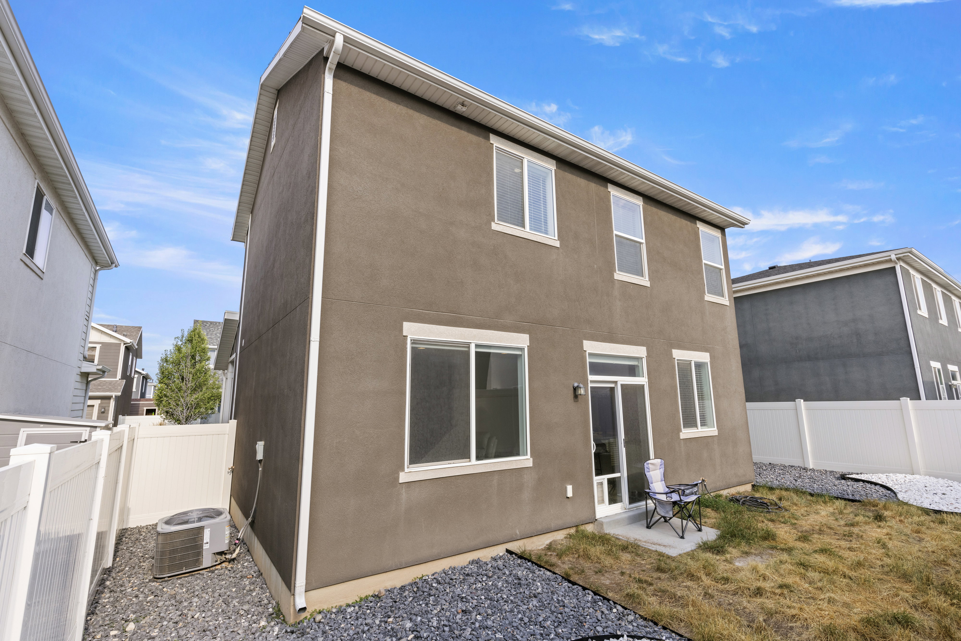 Two-story stucco exterior with white trim and multiple windows