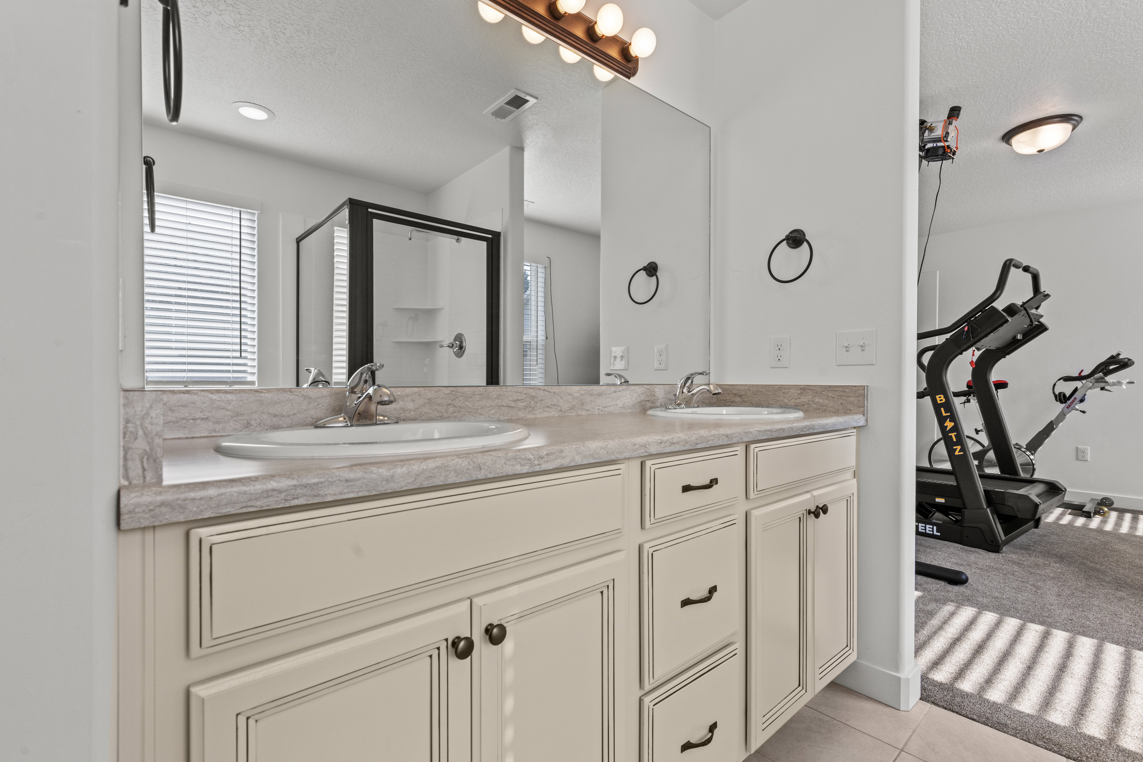 Dual vanity with light-toned cabinetry and a patterned countertop
