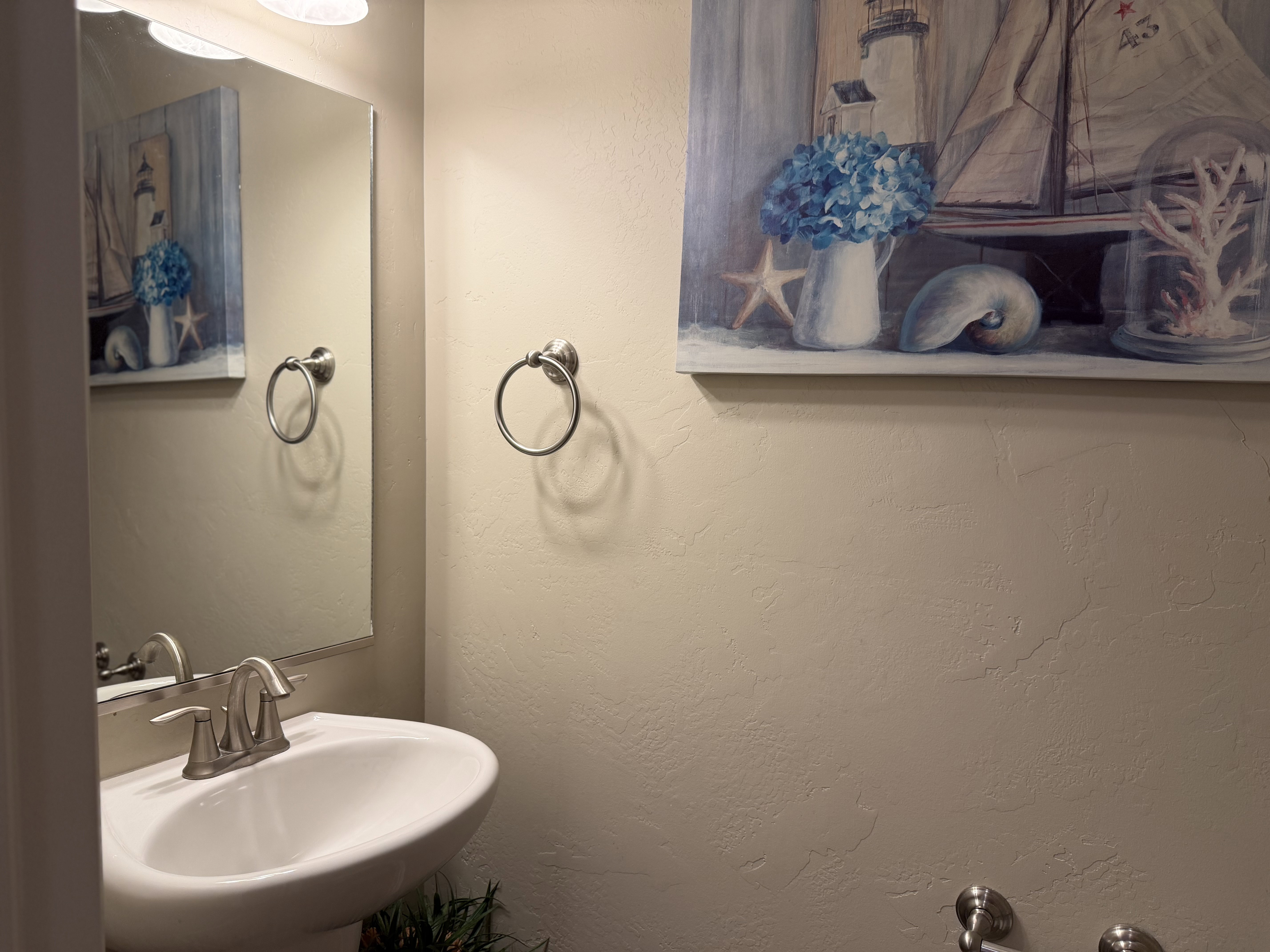 Half bath, Pedestal sink with a brushed nickel faucet and coordinating towel ring