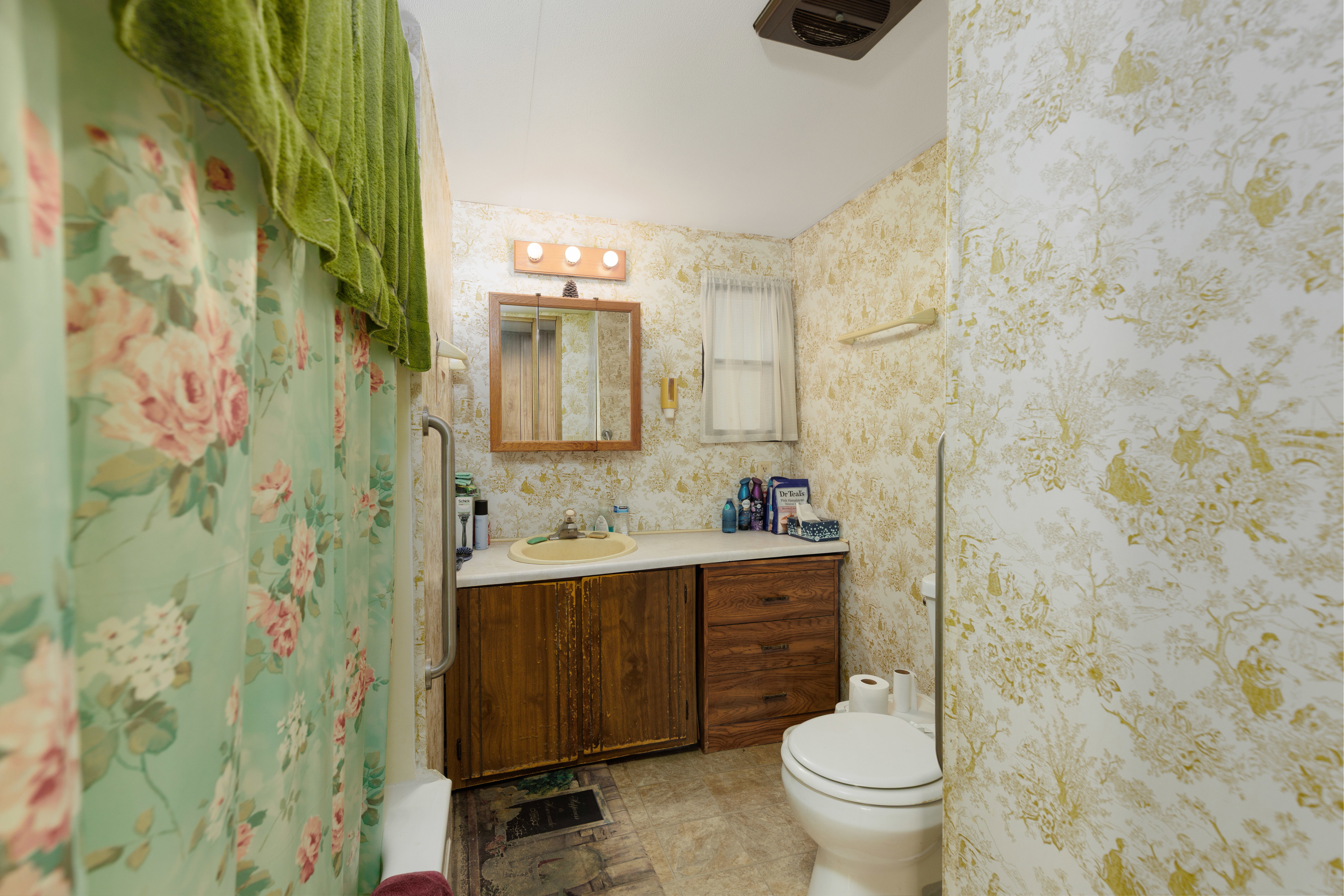 Bathroom featuring a wood-finish vanity with an integrated sink and laminate countertop