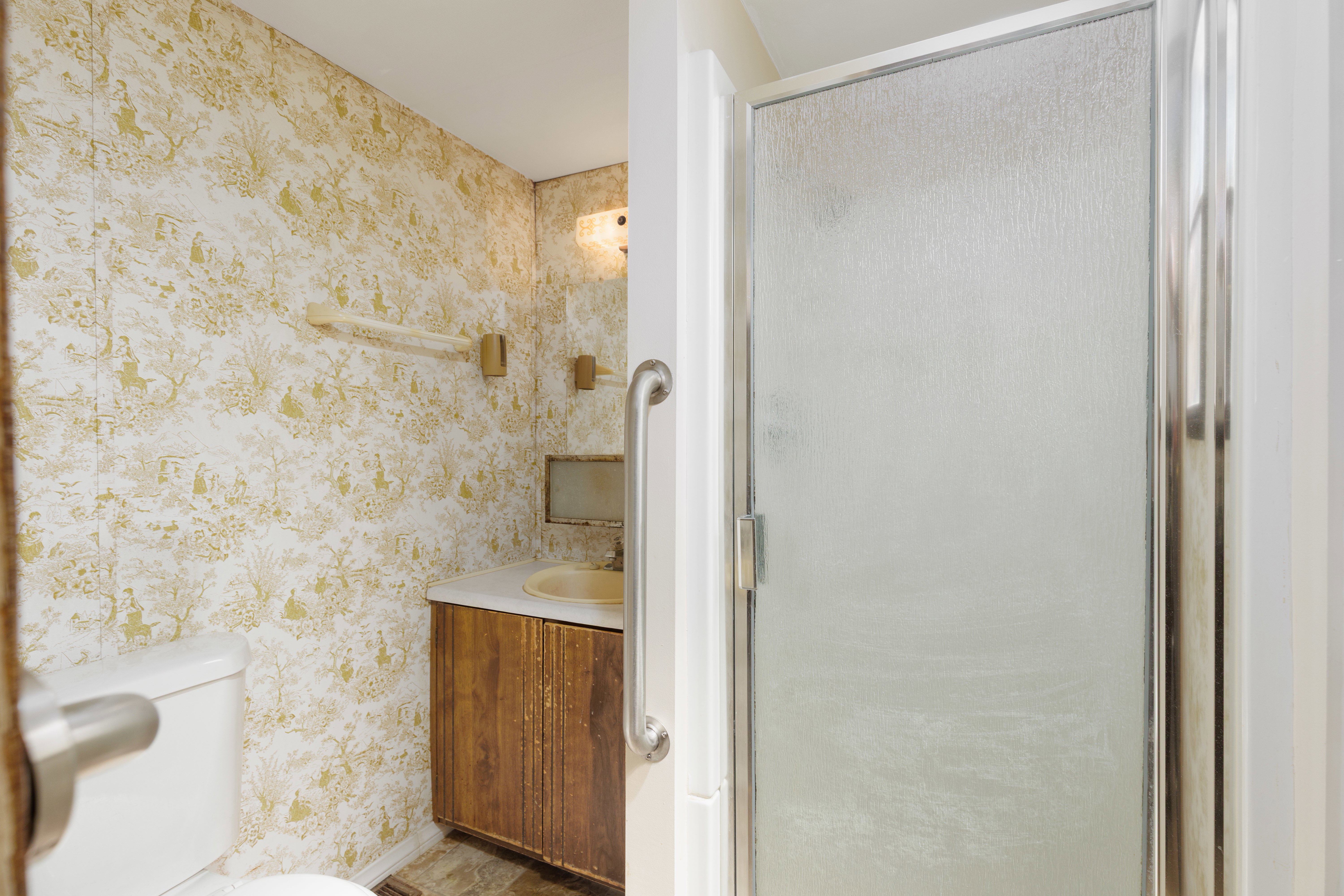 Bathroom featuring a shower enclosure with a frosted glass door and chrome frame