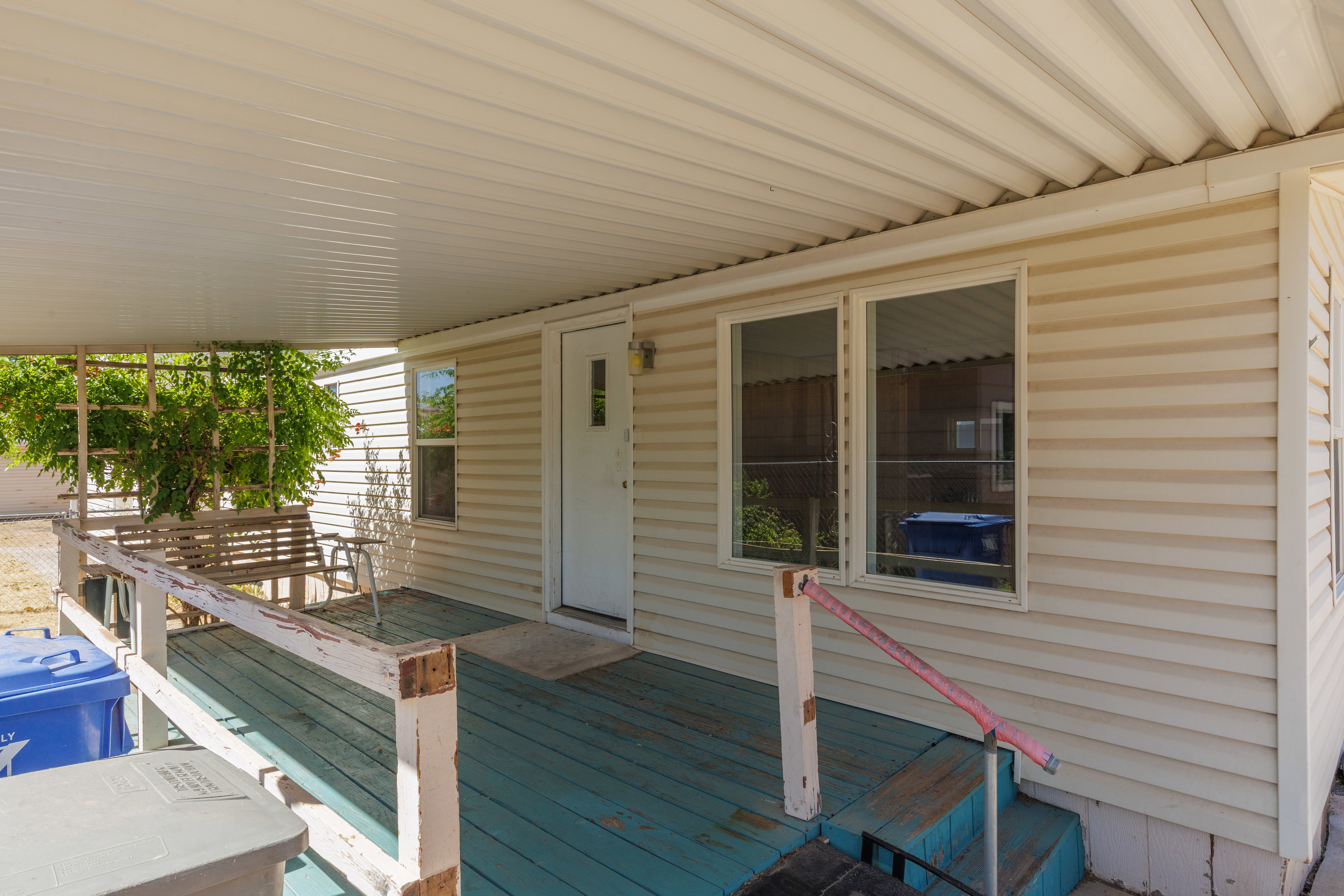 Covered front porch with a wood-finish floor and white railing