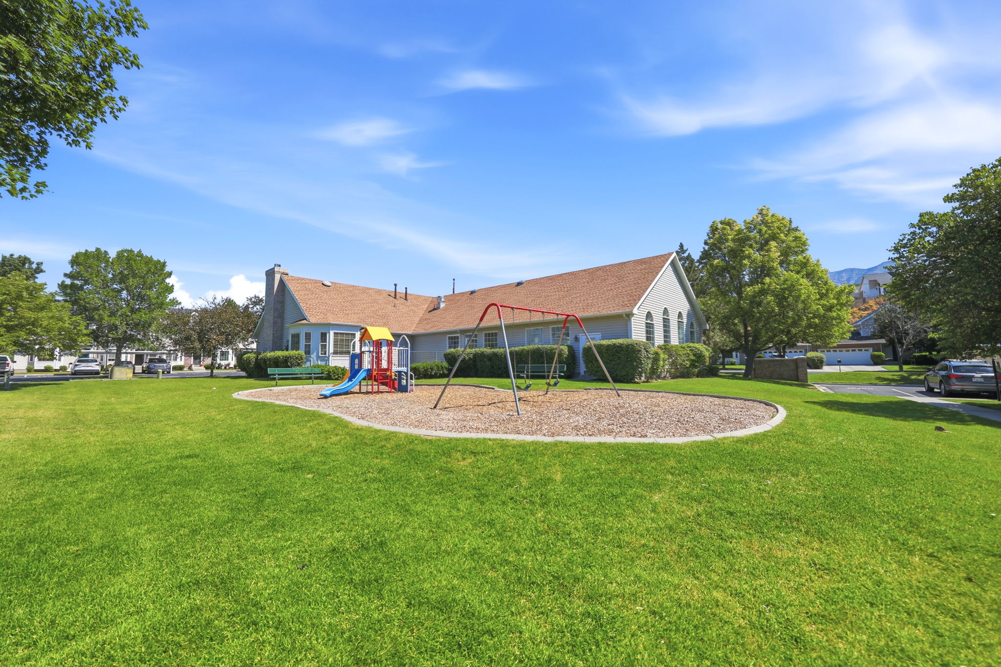Expansive green space featuring a playground with swings and a slide