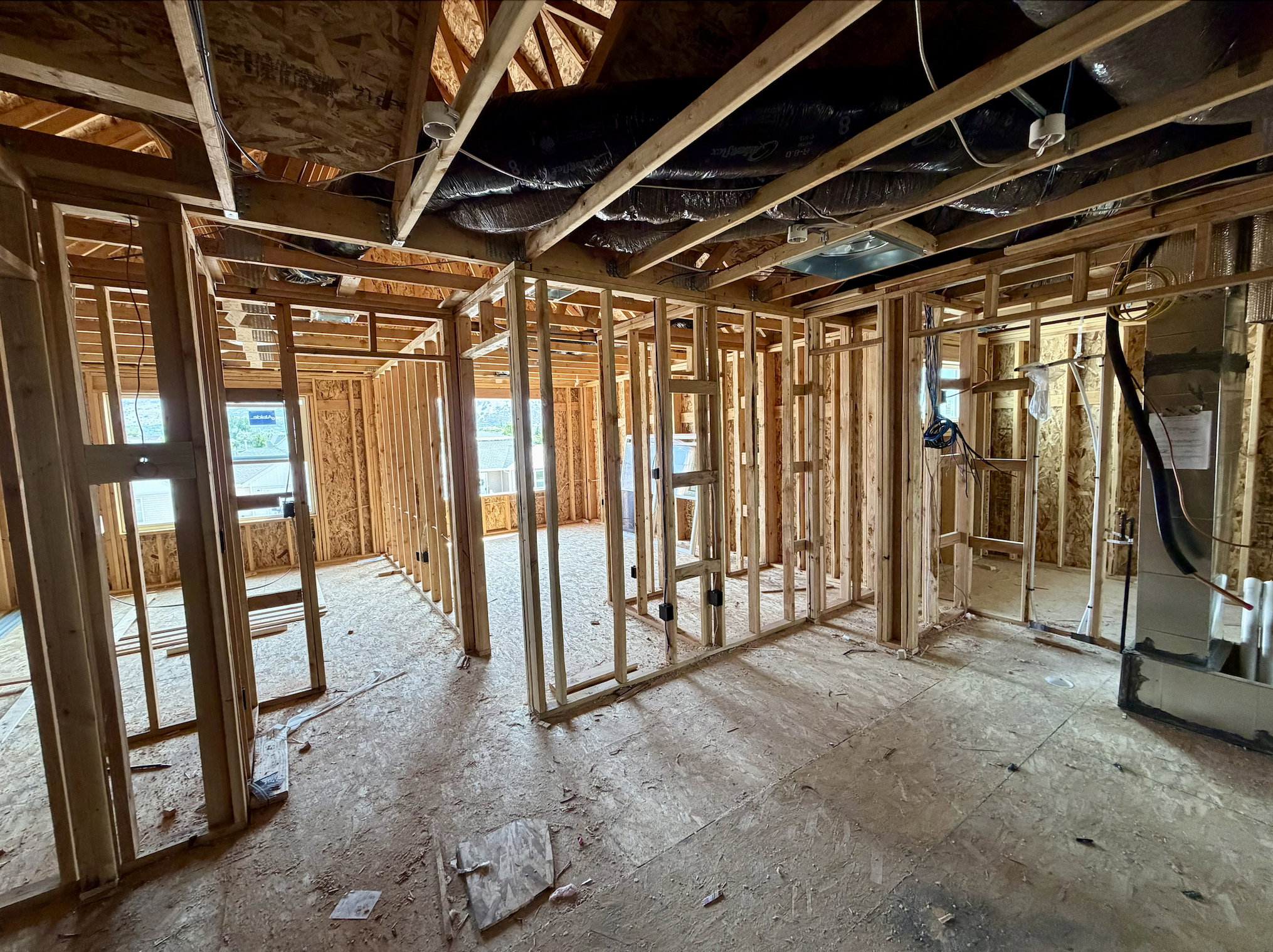 Interior framing showcasing wood studs and engineered wood subflooring