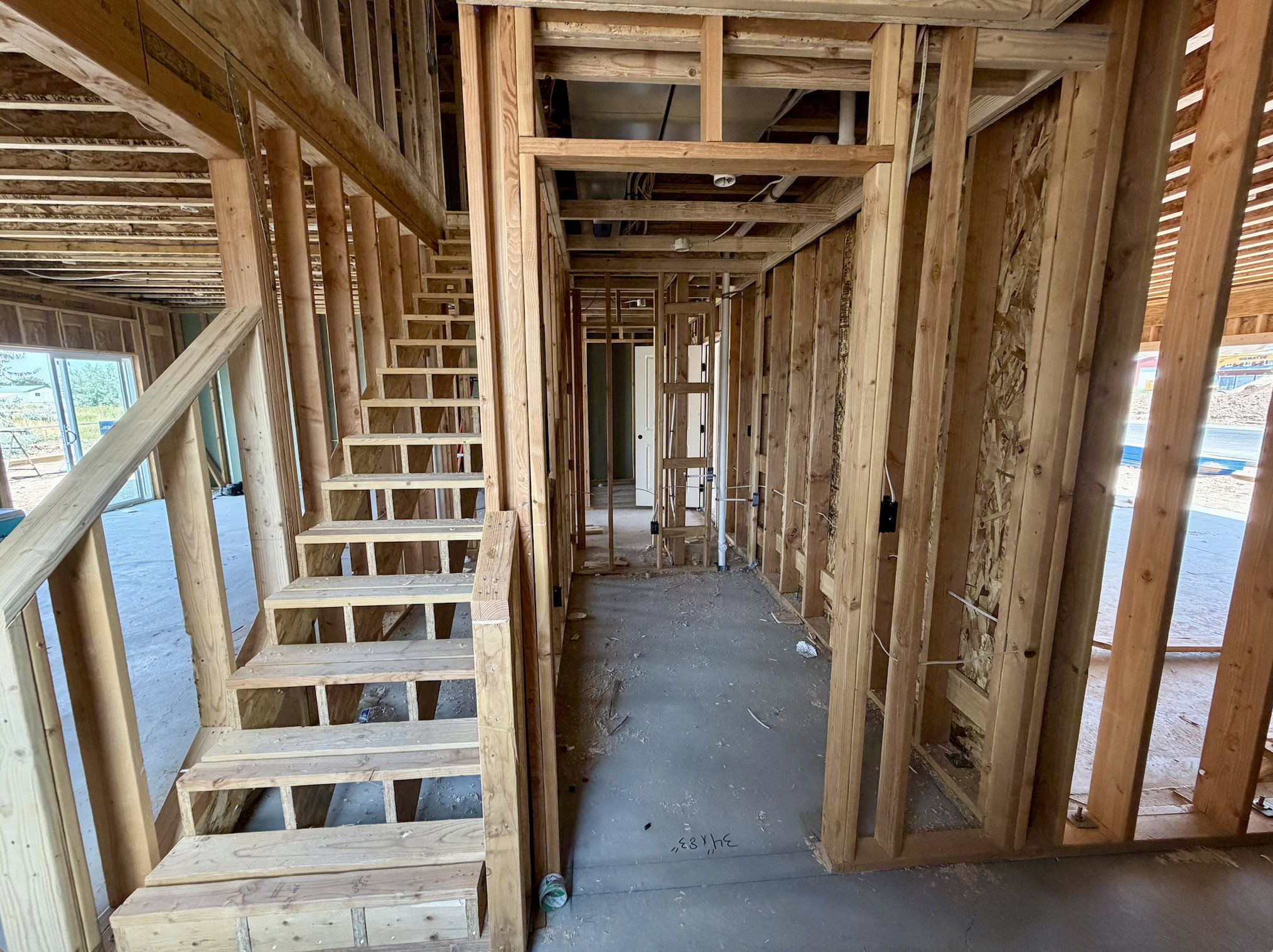 Exposed wooden framing throughout with a prominent wooden staircase featuring open risers