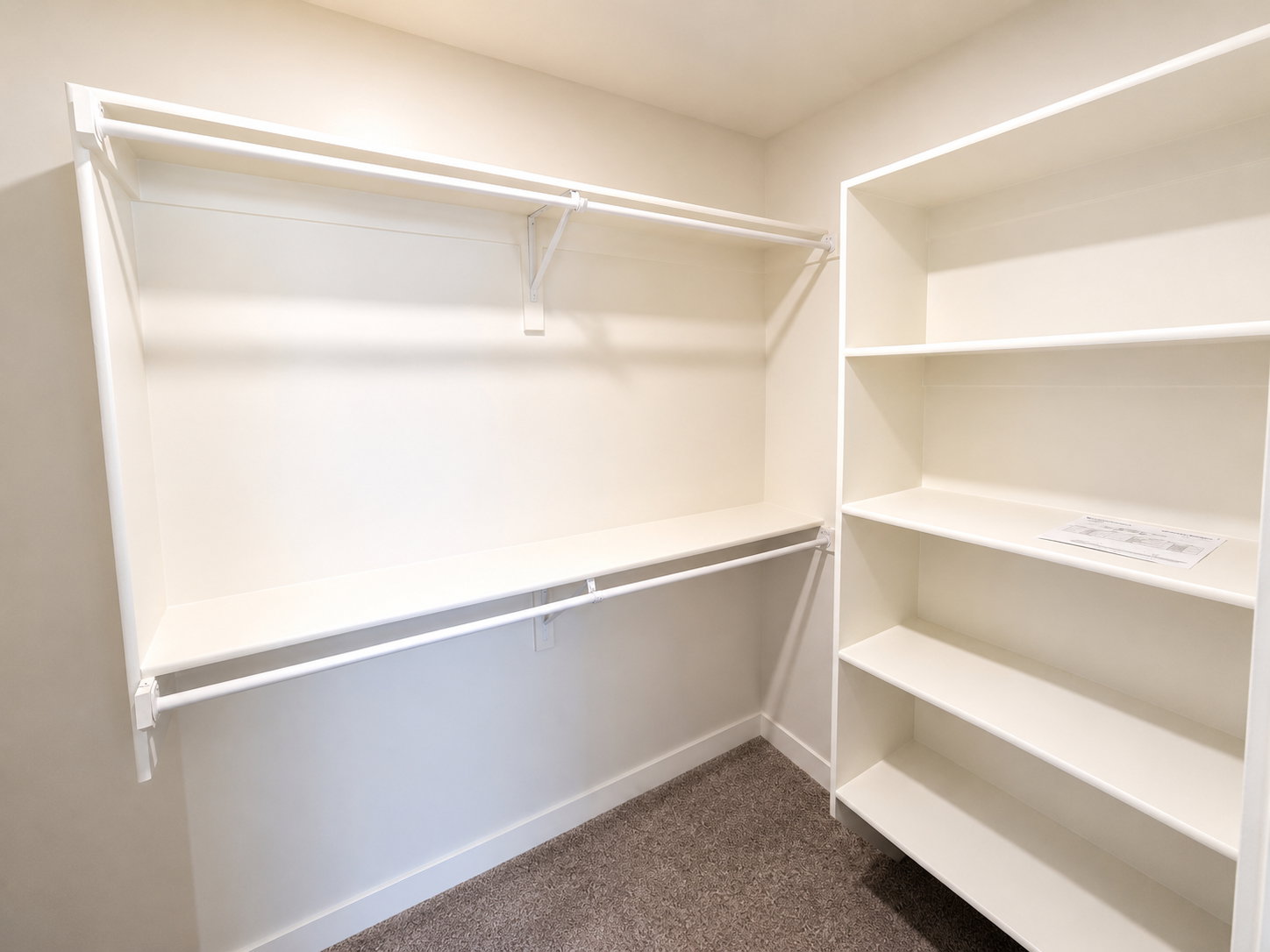 Walk-in closet with built-in shelving, dual hanging rods, and a neutral carpeted floor