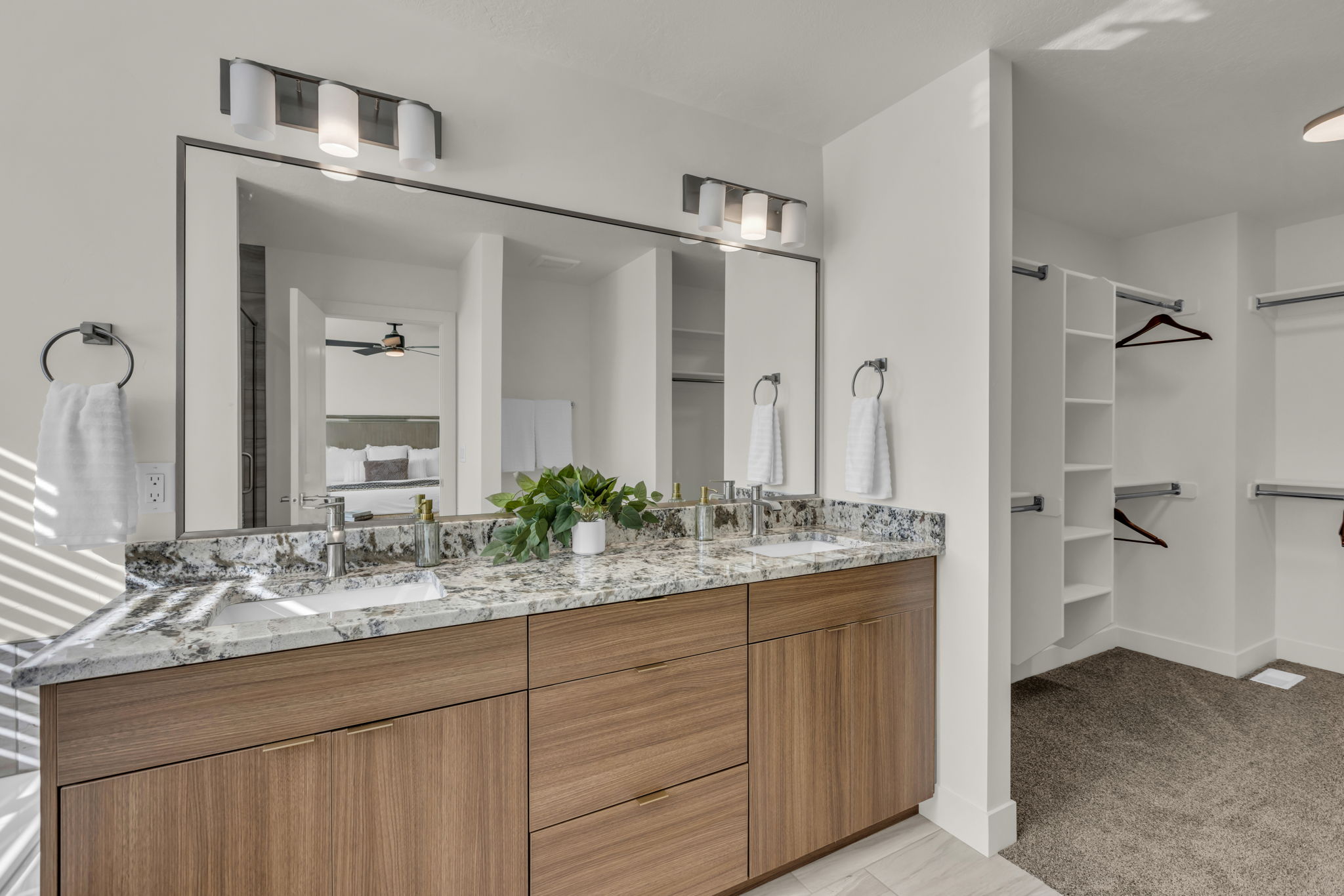 Bathroom vanity featuring dual under-mount sinks, a stone countertop, and wood-finish cabinetry