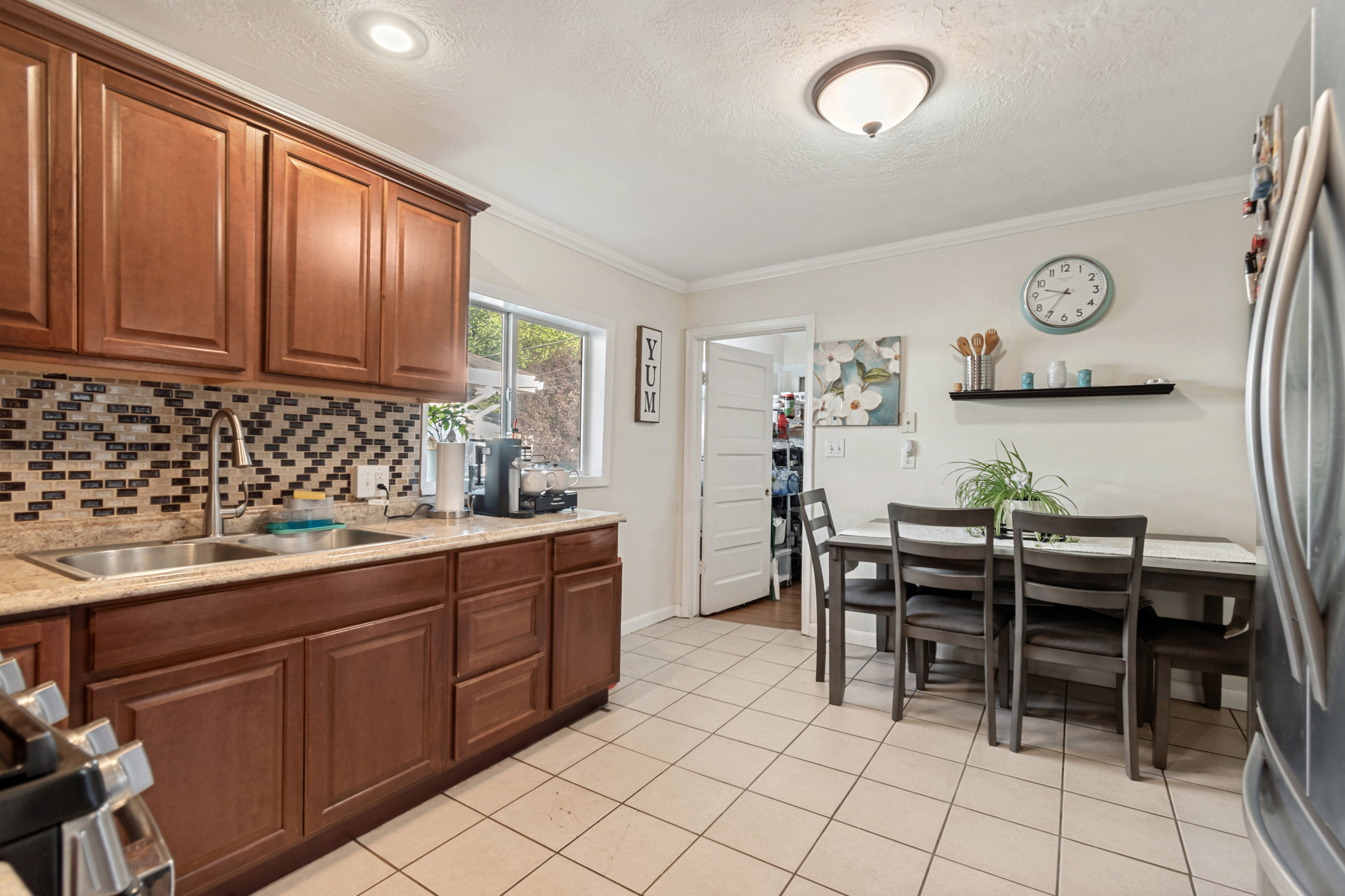 Kitchen featuring wood cabinetry, granite countertops, and a mosaic tile backsplash