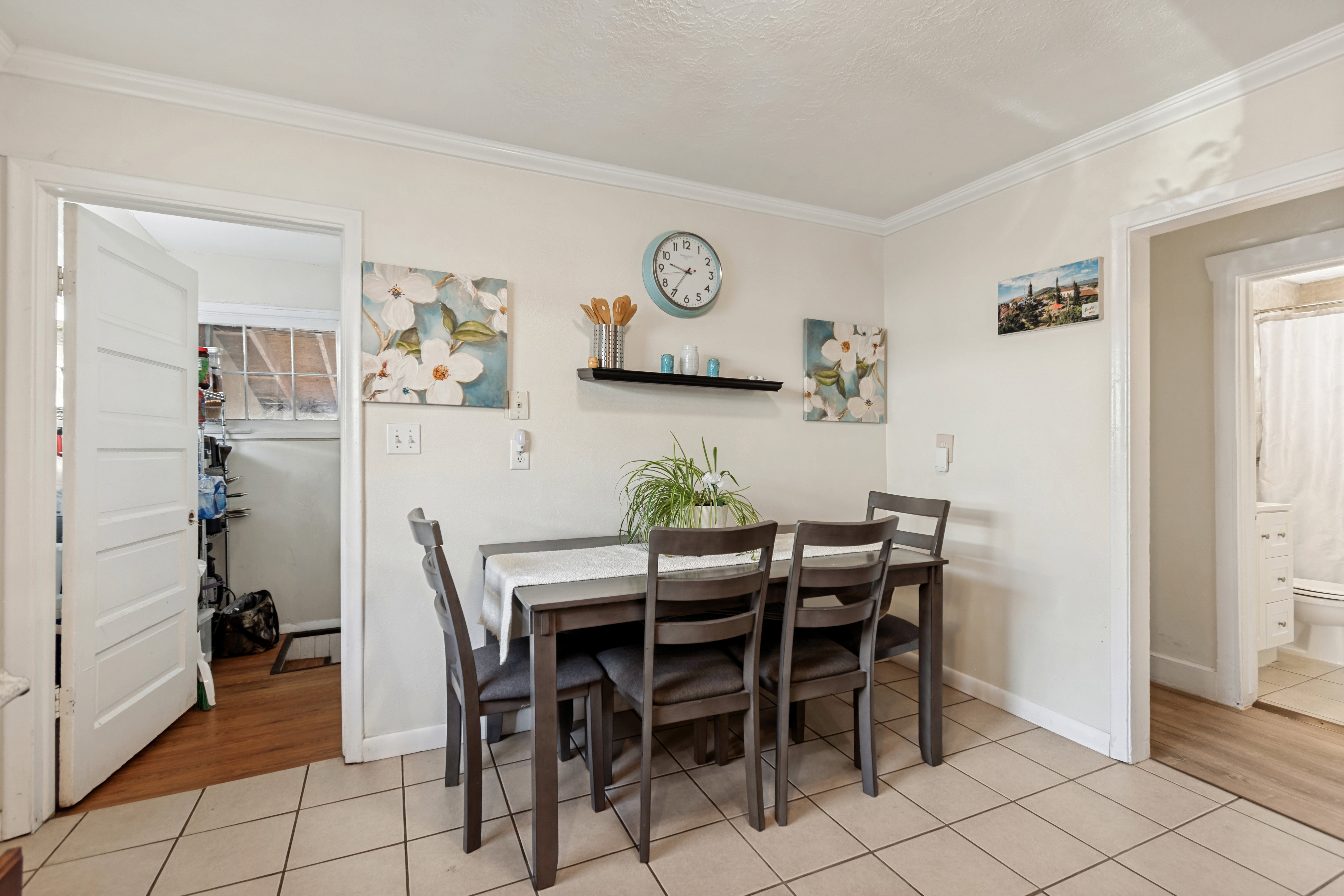 Dining area featuring ceramic tile flooring, neutral wall tones, and crown molding