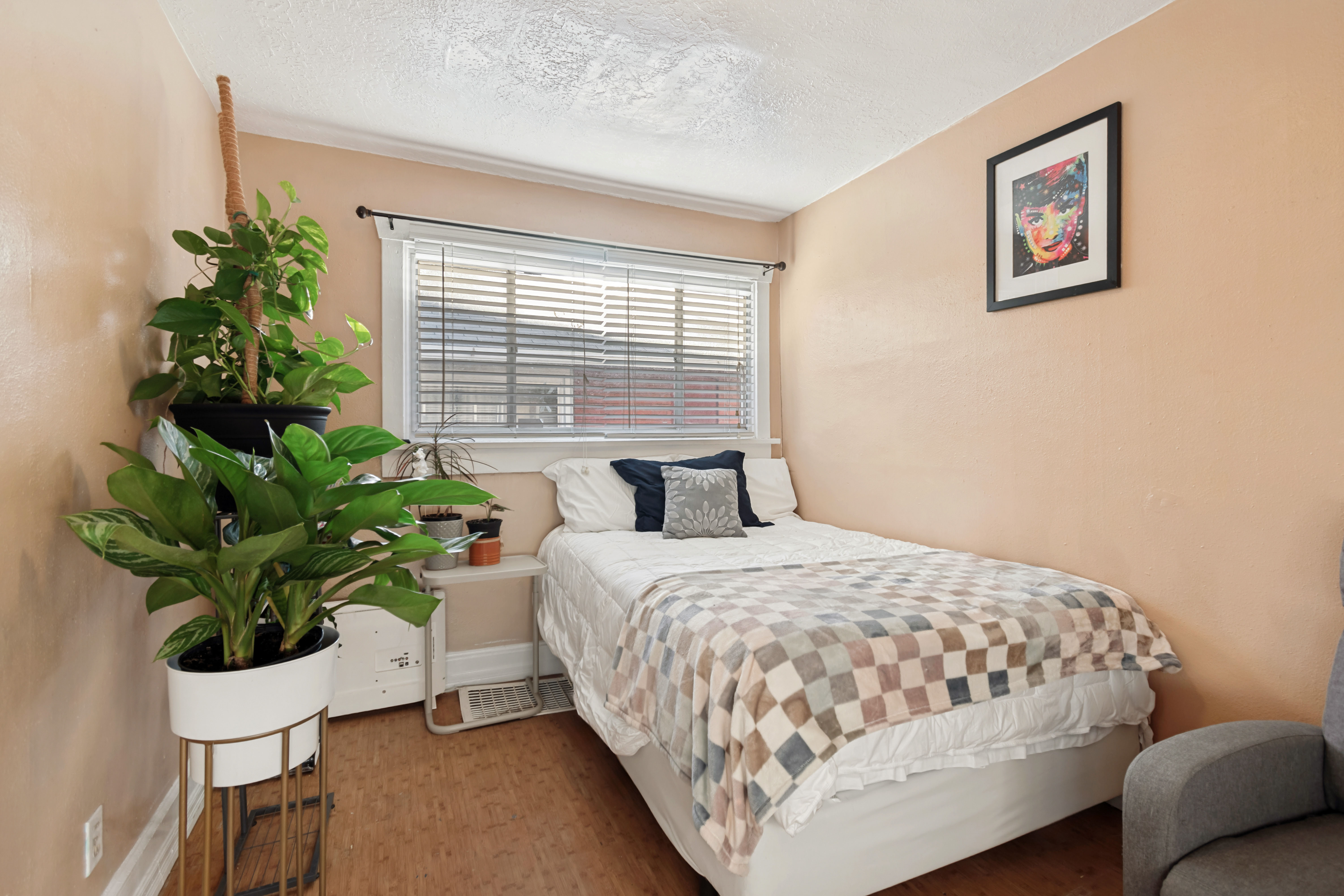 Bedroom featuring wood-finish flooring, a window with blinds, and light-toned walls